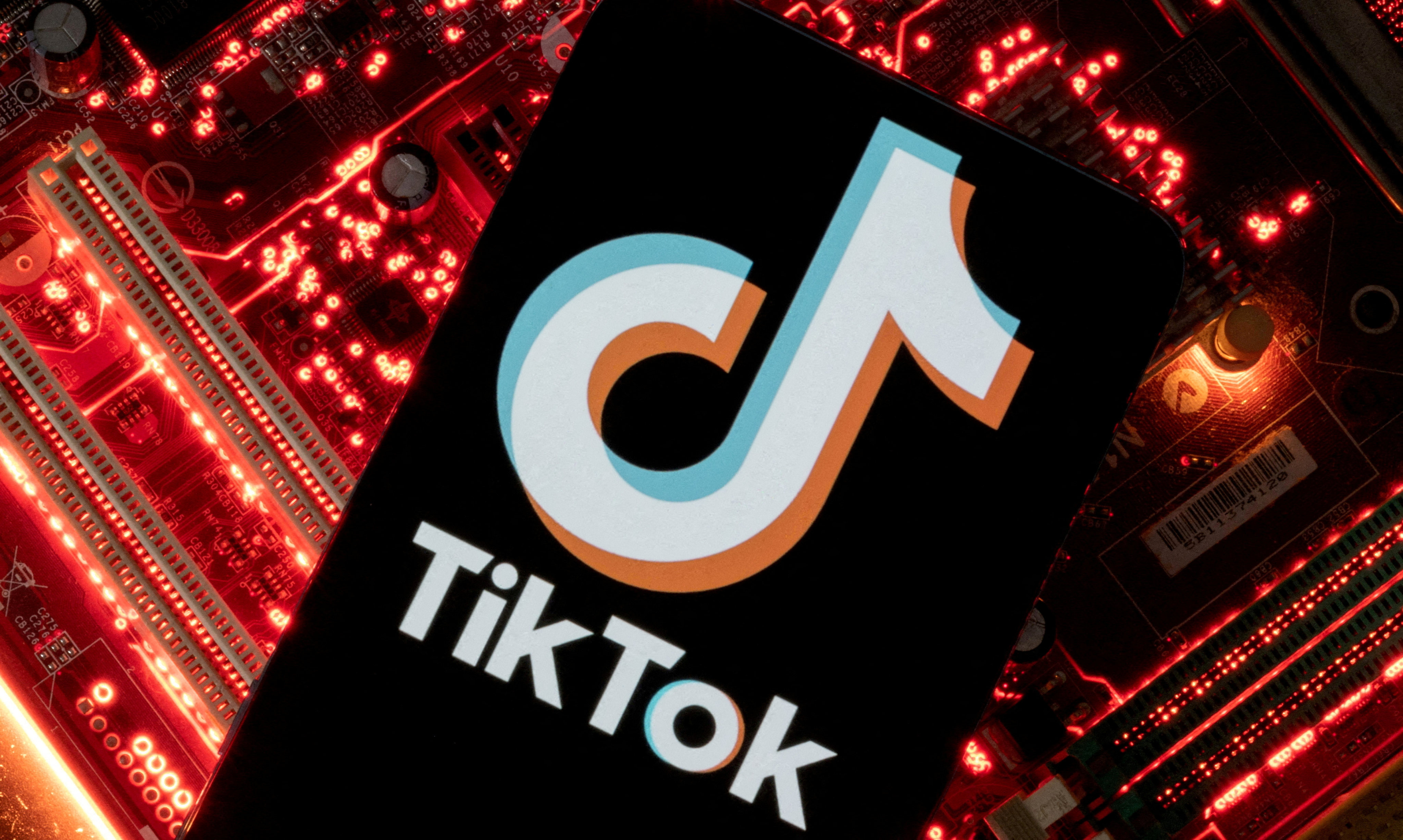 A smartphone with a displayed TikTok logo atop a computer motherboard in this illustration taken February 23, 2023. Photo: Reuters