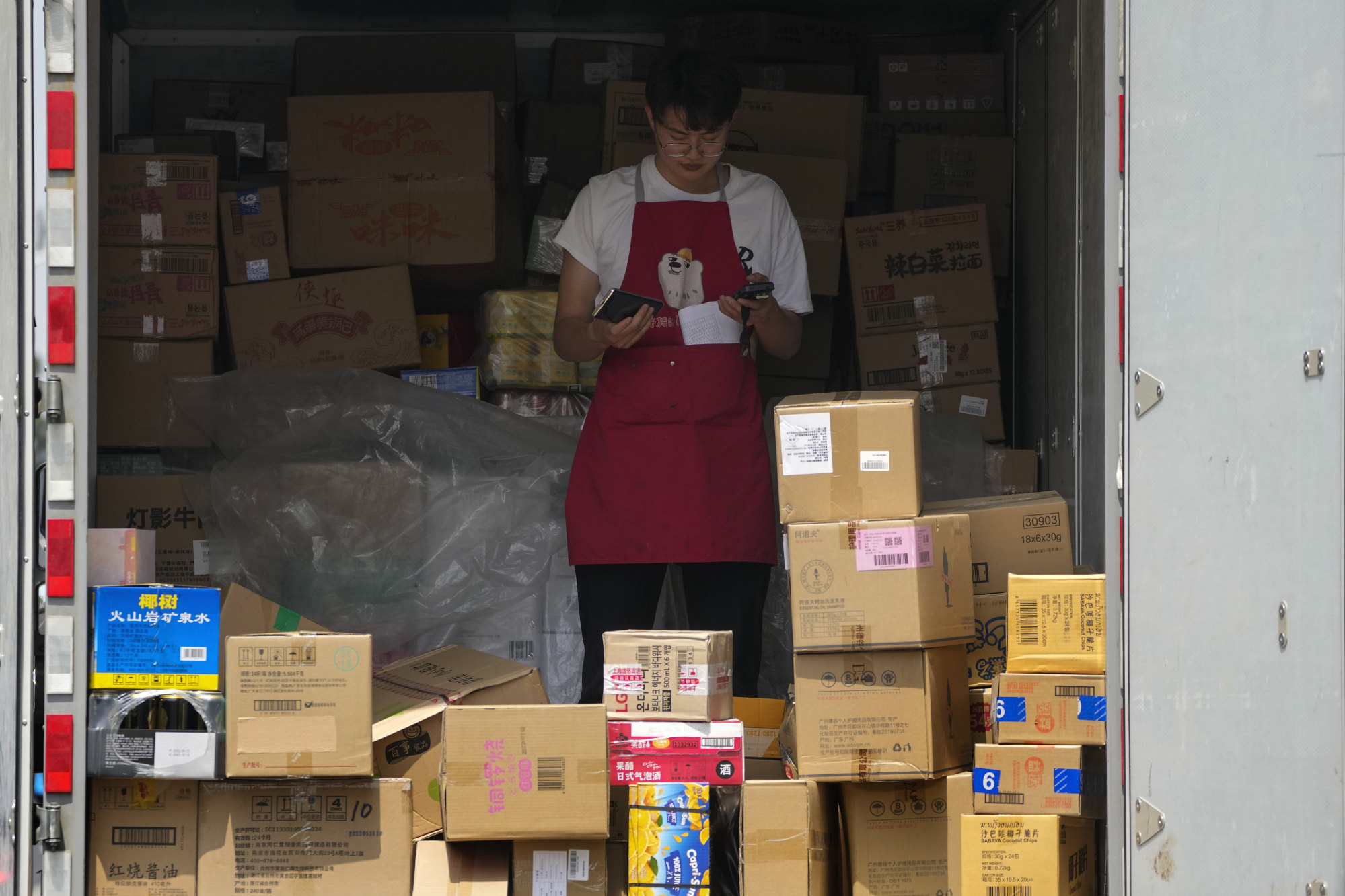 A worker take stock inside a truck loaded with goods in Beijing. Photo: AP Photo