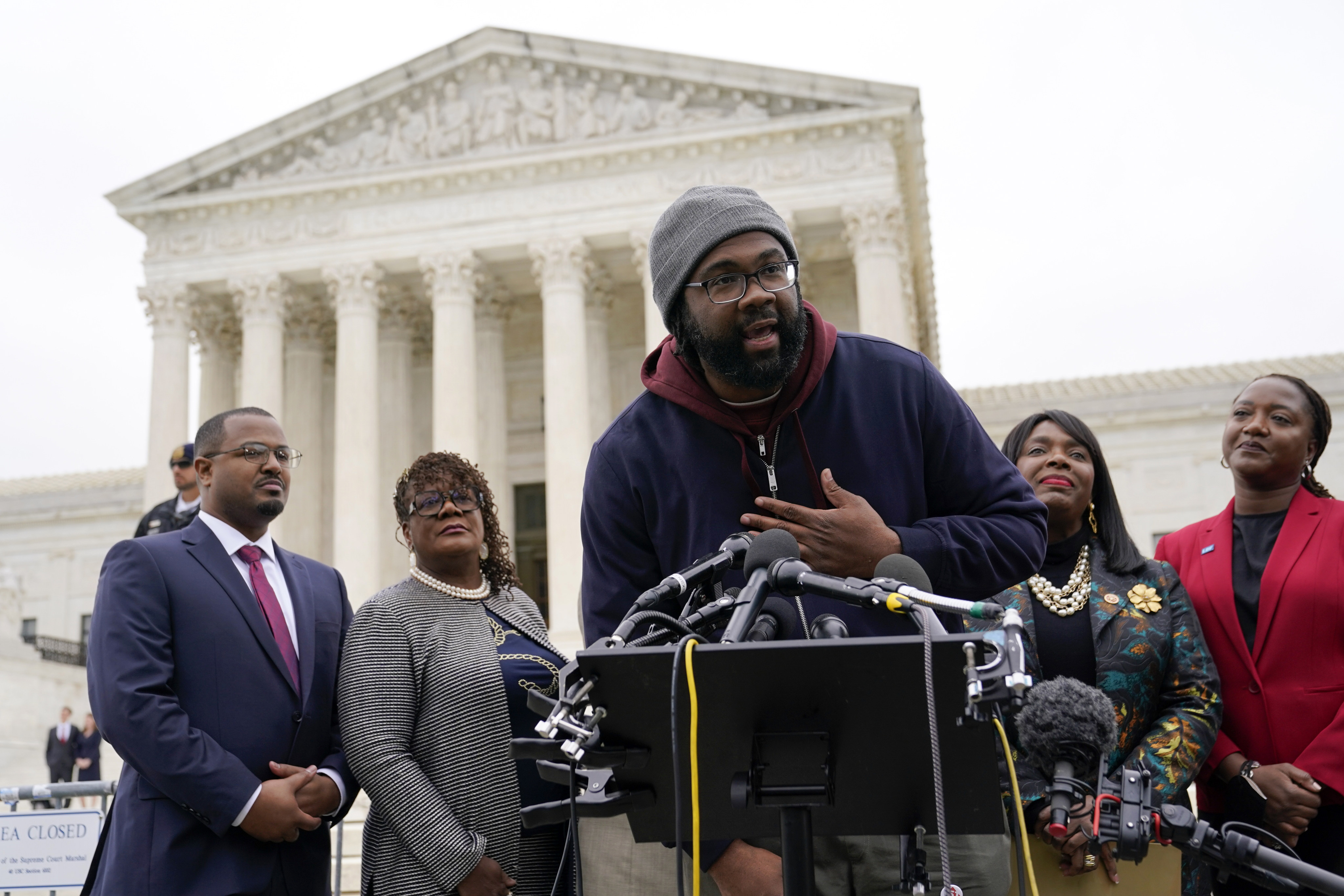 Evan Milligan, plaintiff in an Alabama redistricting case, speaks with members of the press outside the US Supreme Court in October 2022. Photo: AP