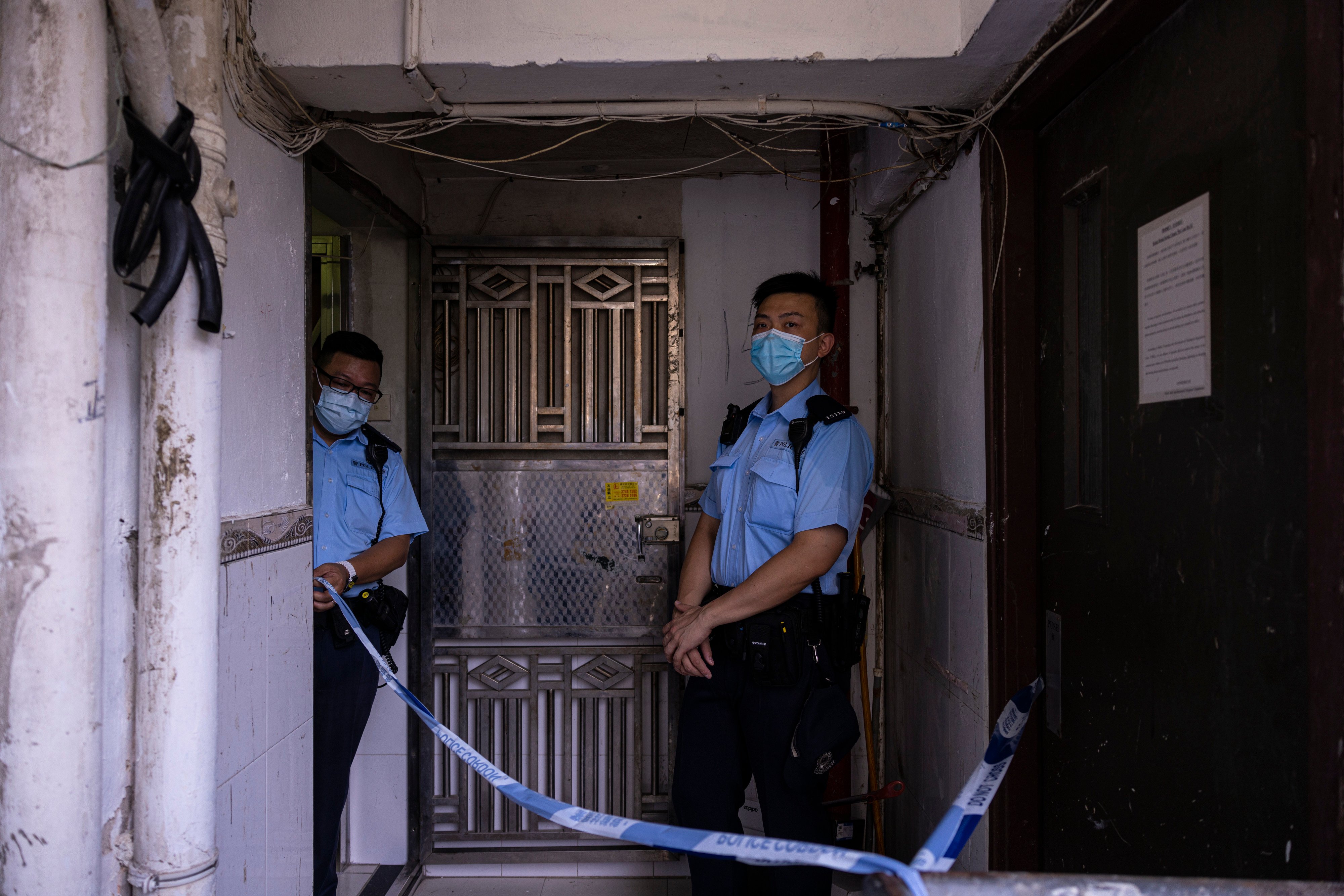 Police officers stand outside an apartment where three children were killed in Sham Shui Po in Hong Kong, on June 5. Photo: AP