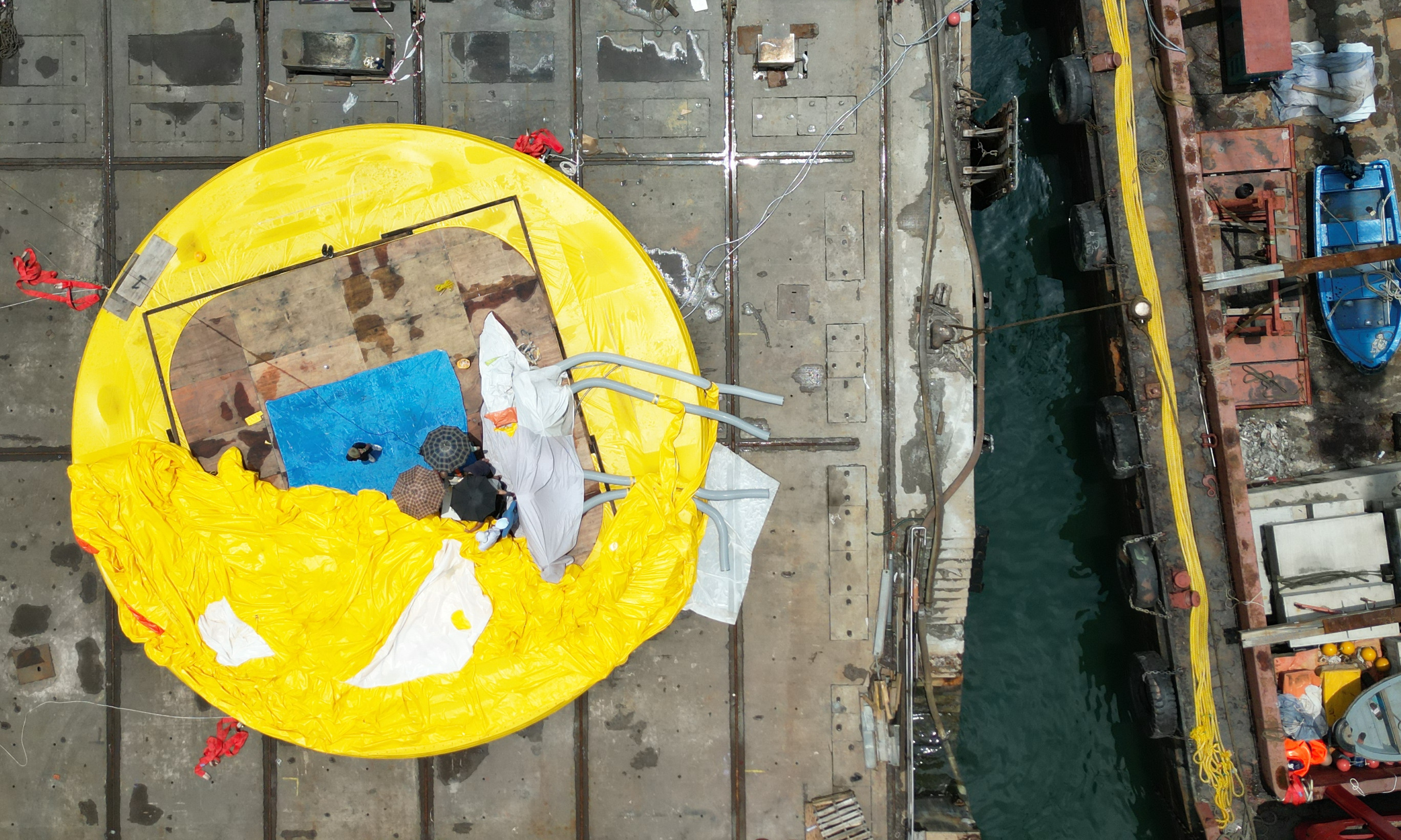 Workers try to repair the deflated giant rubber duck at a shipyard in Tsing Yi. Photo: Sam Tsang