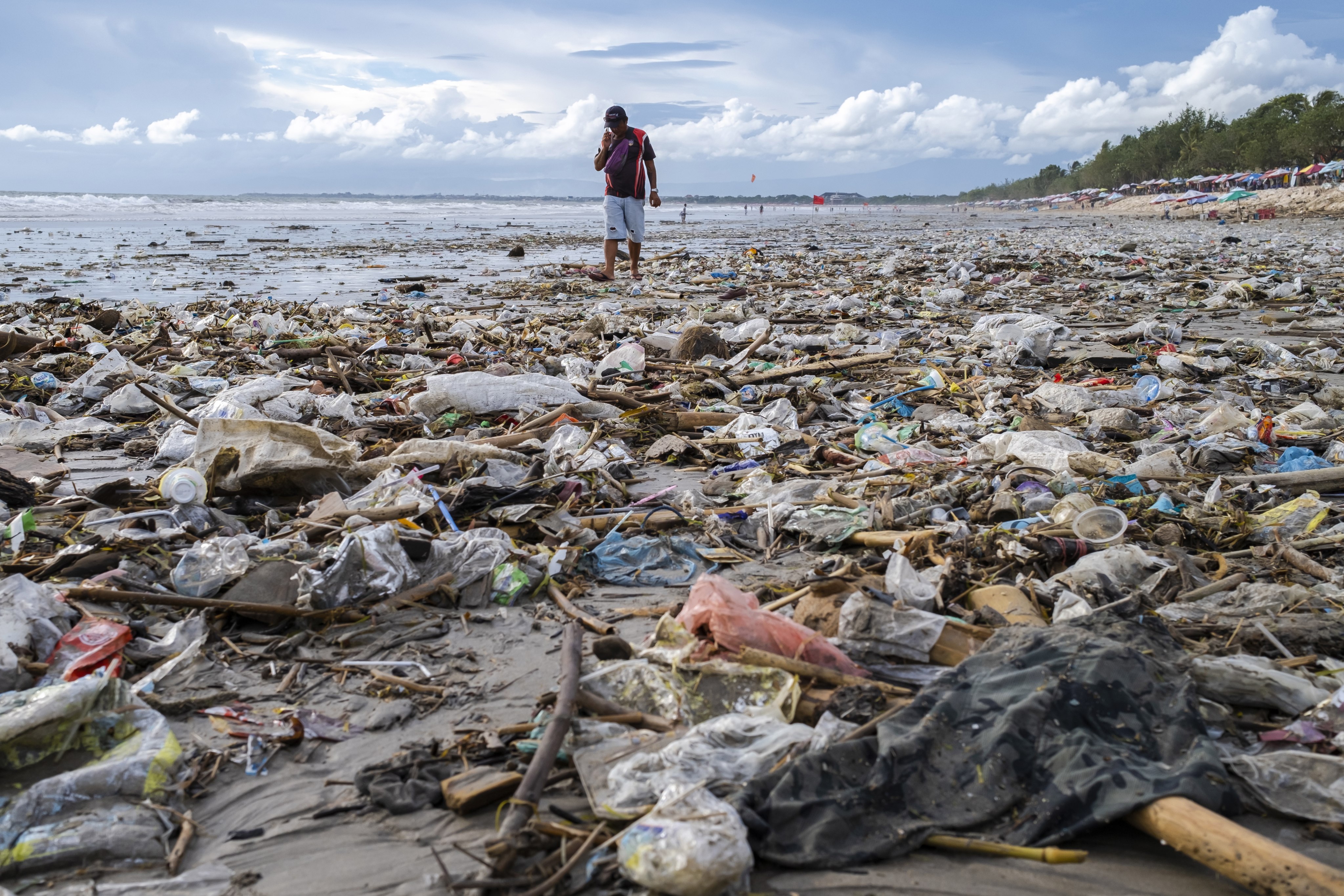 A man walks among waste washed ashore in Bali, Indonesia, in April. Photo: EPA-EFE