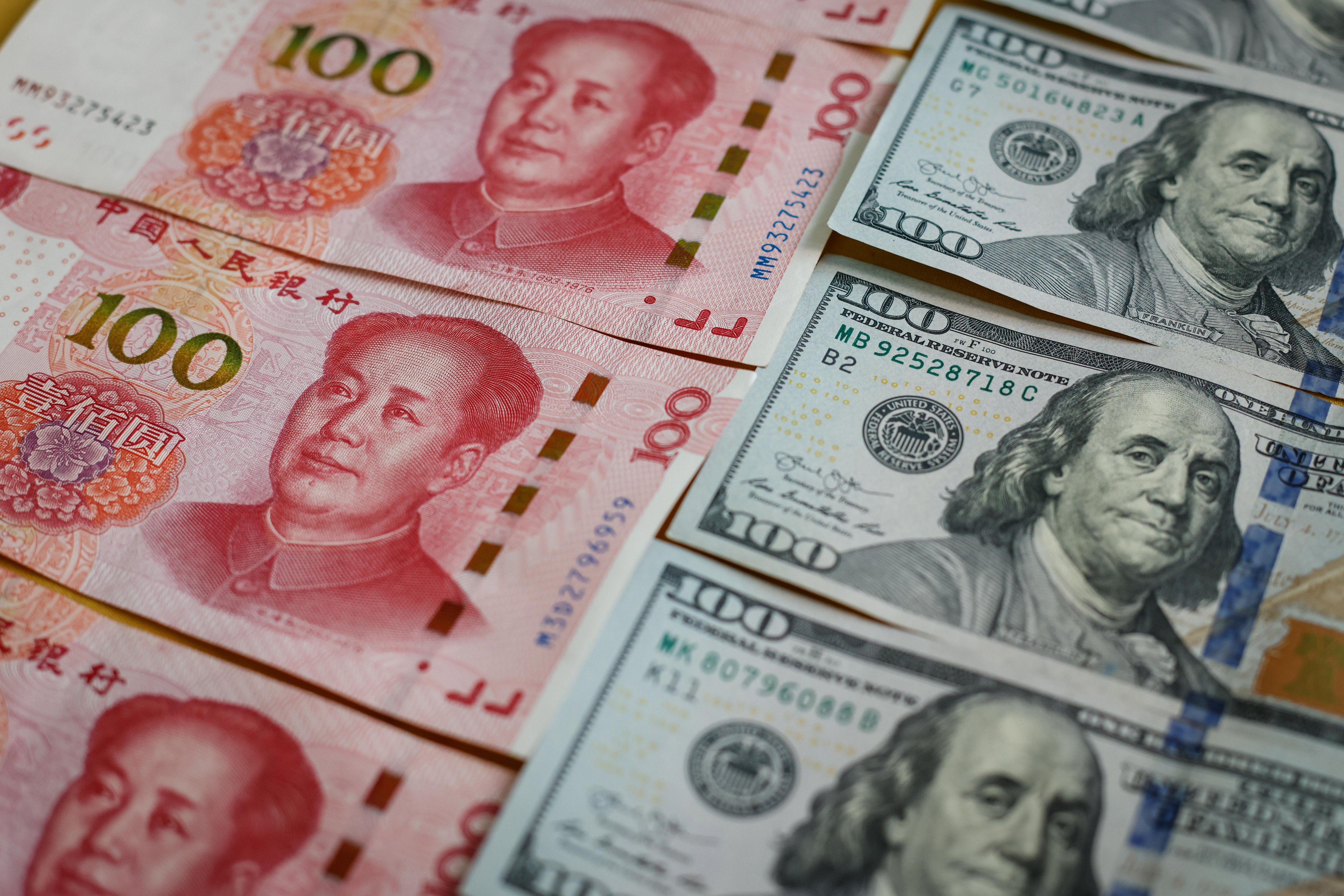 An illustration shows the 100 Chinese yuan and 100 US dollar bills. Photo: EPA-EFE