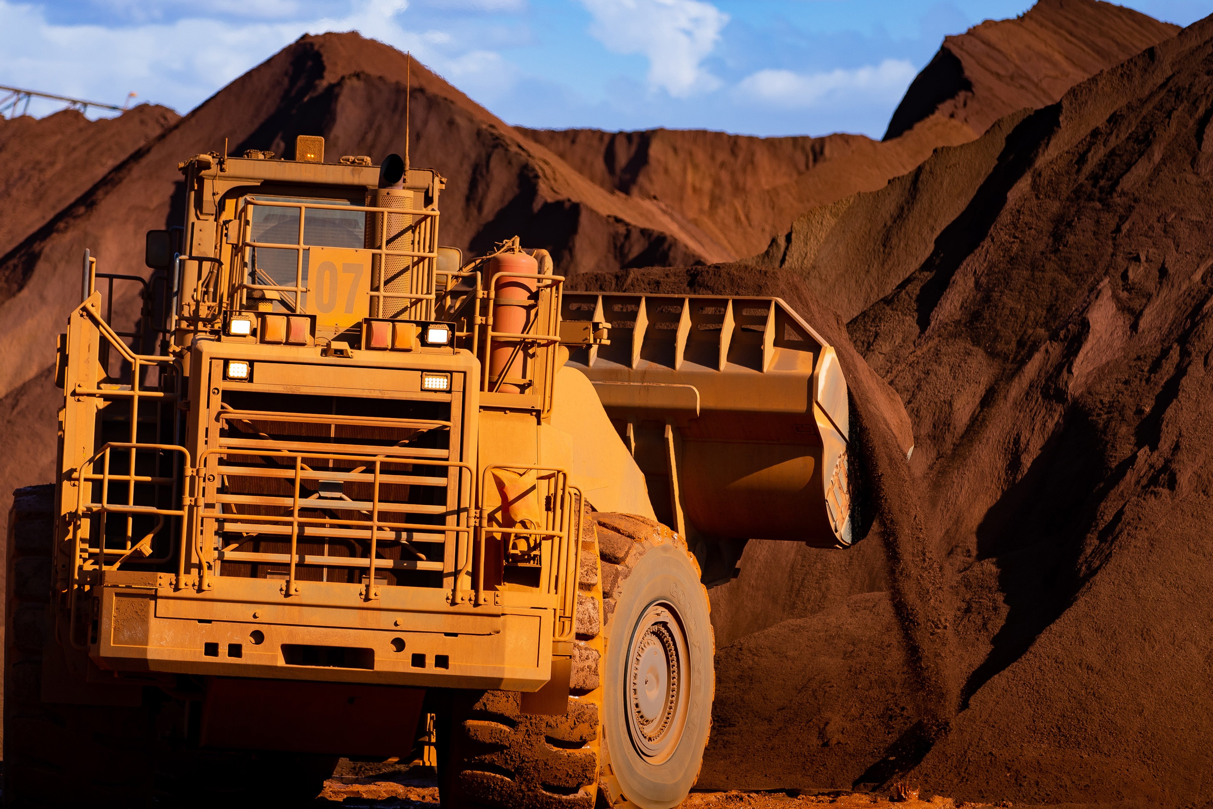 An excavator moves iron ore at Port Hedland, Australia. Photo: Bloomberg