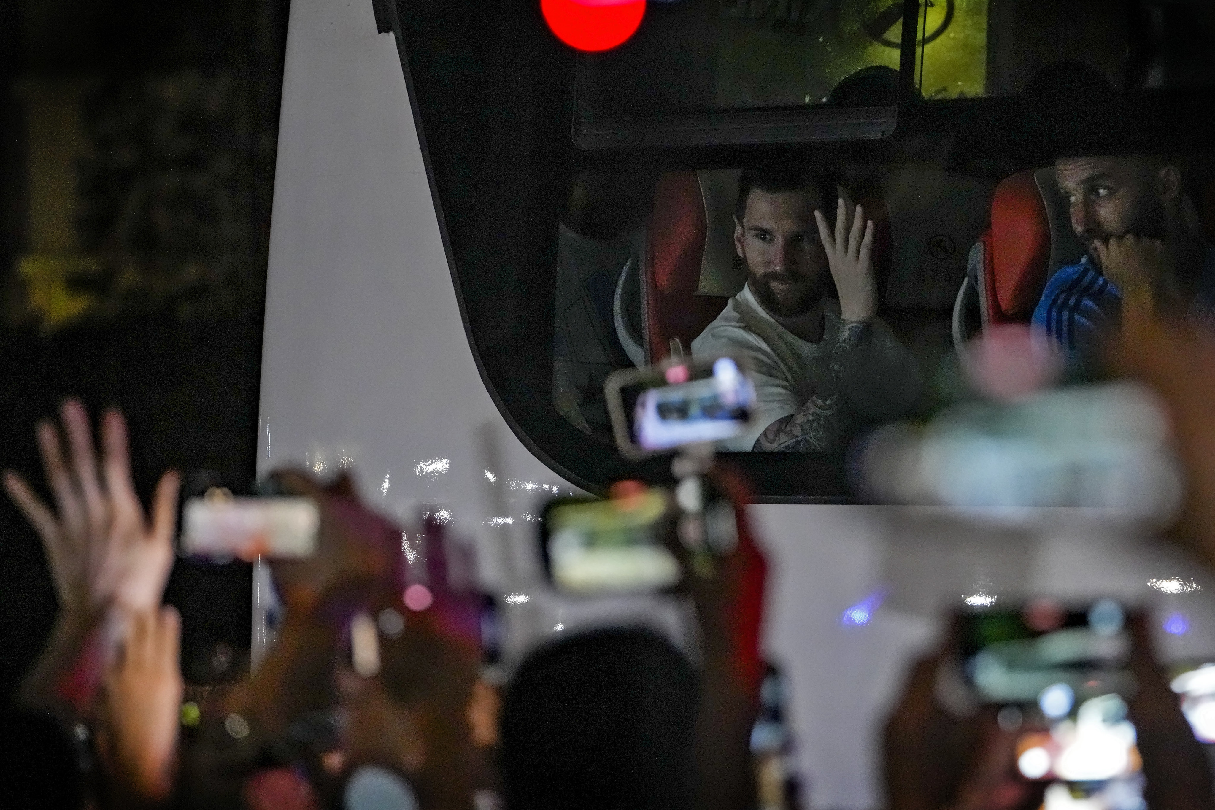 Chinese fans cheer and film as they catch a glimpse of Lionel Messi gesturing on a bus as he and other members of the Argentina national football team return to their hotel in Beijing on June 13, 2023. Photo: AP