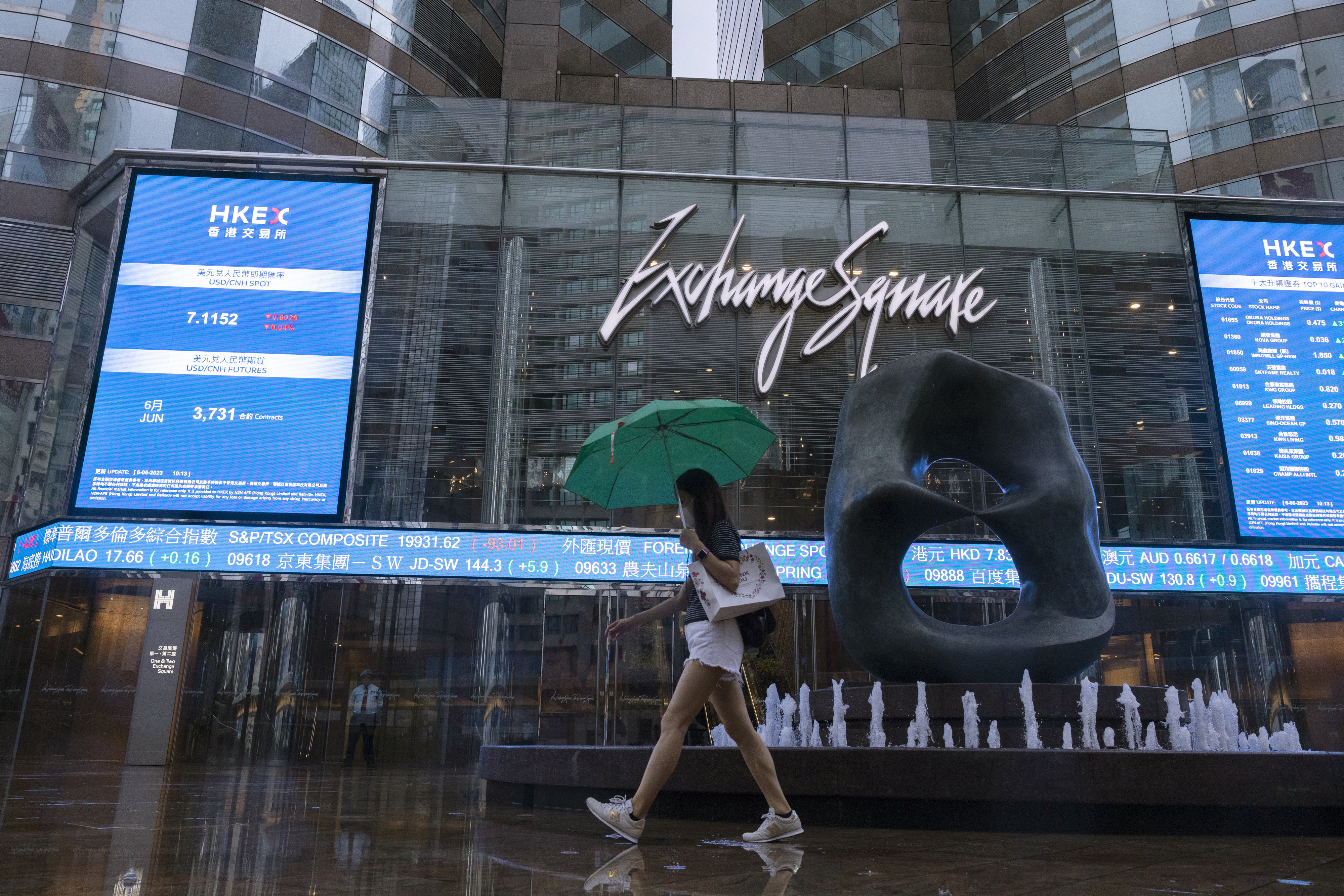 A pedestrian passes by Exchange Square, the building housing the Hong Kong Stock Exchange, on June 6, 2023. Photo: AP