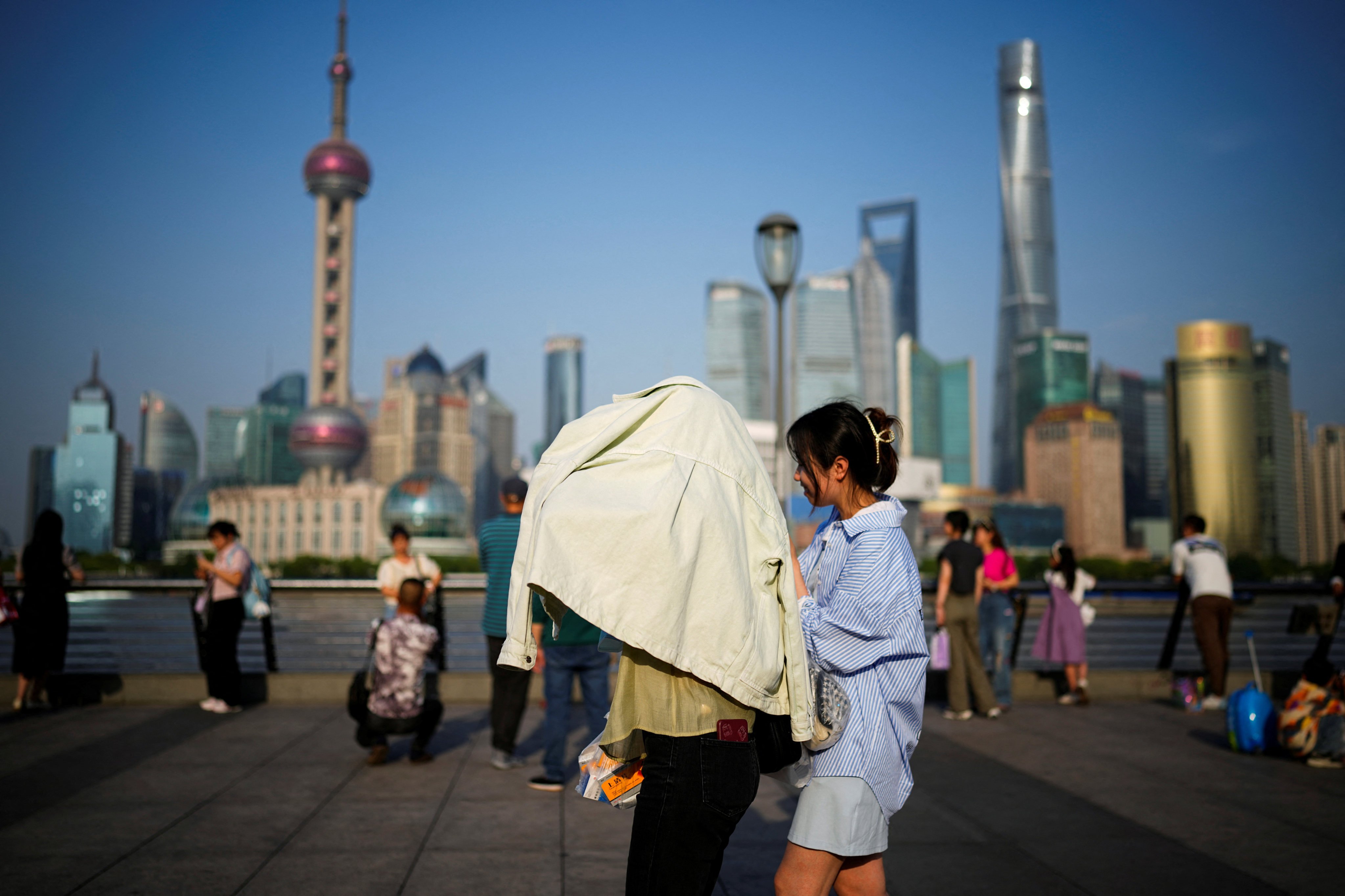 A person uses clothing to protect themselves from the sun in Shanghai, May 15, 2023. Photo: Reuters 