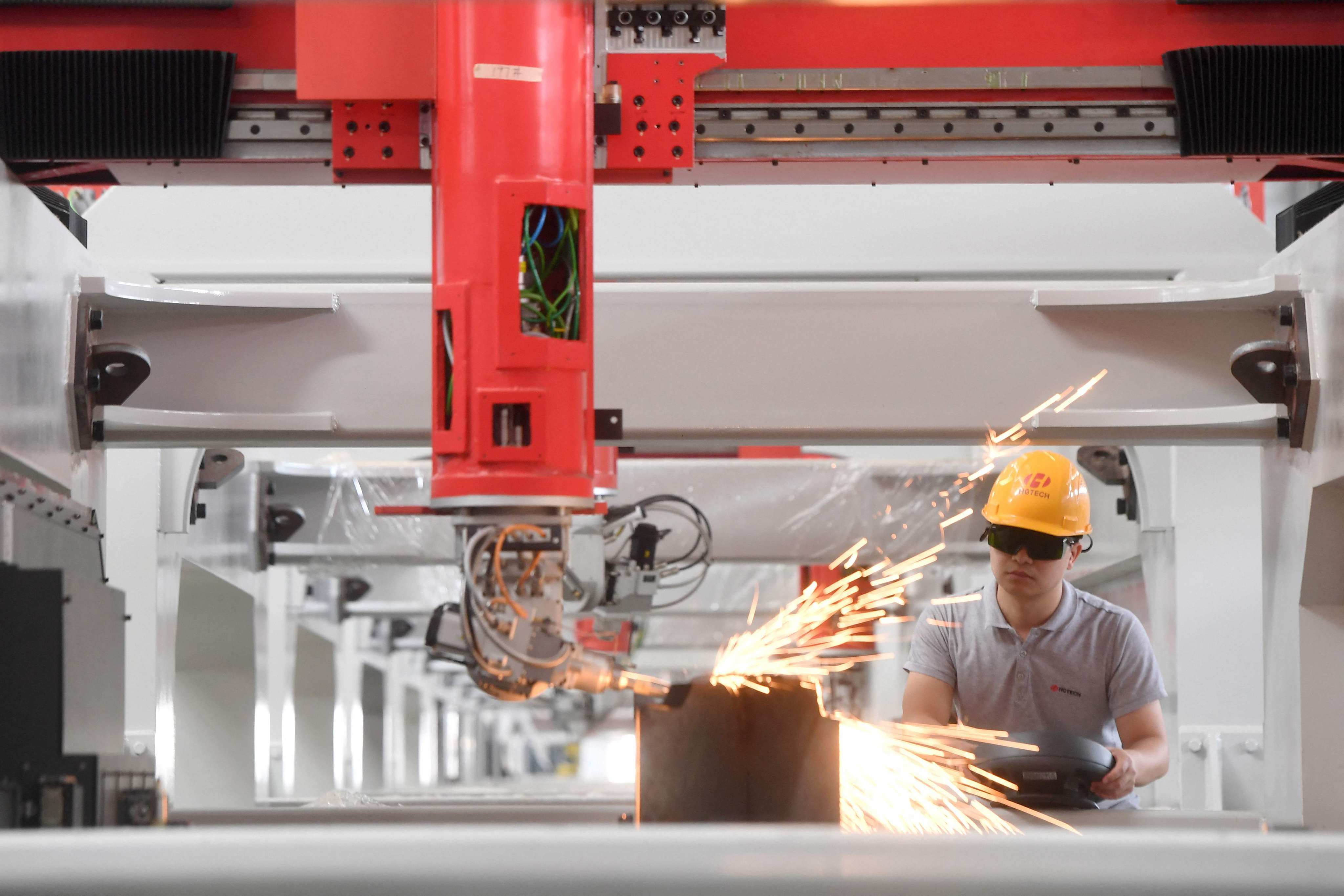 An engineer checks a laser-cutting machine, to be sold to automotive manufacturers for the production of new energy vehicles, at a facility in Wuhan, in China’s central Hubei province on June 12. Photo: AFP