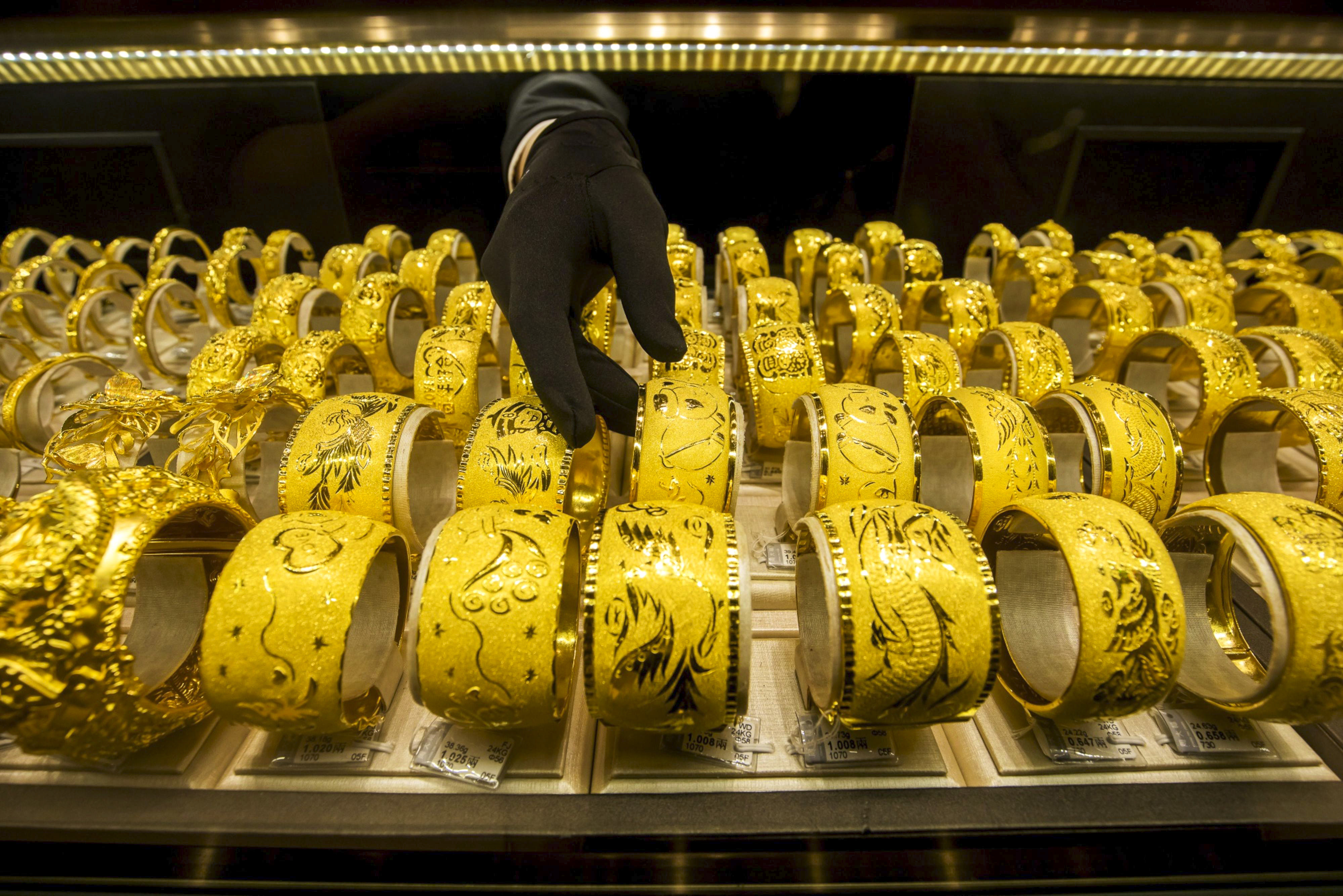 An employee arranges gold bangles in a Chow Tai Fook jewellery shop. Photo: Bloomberg
