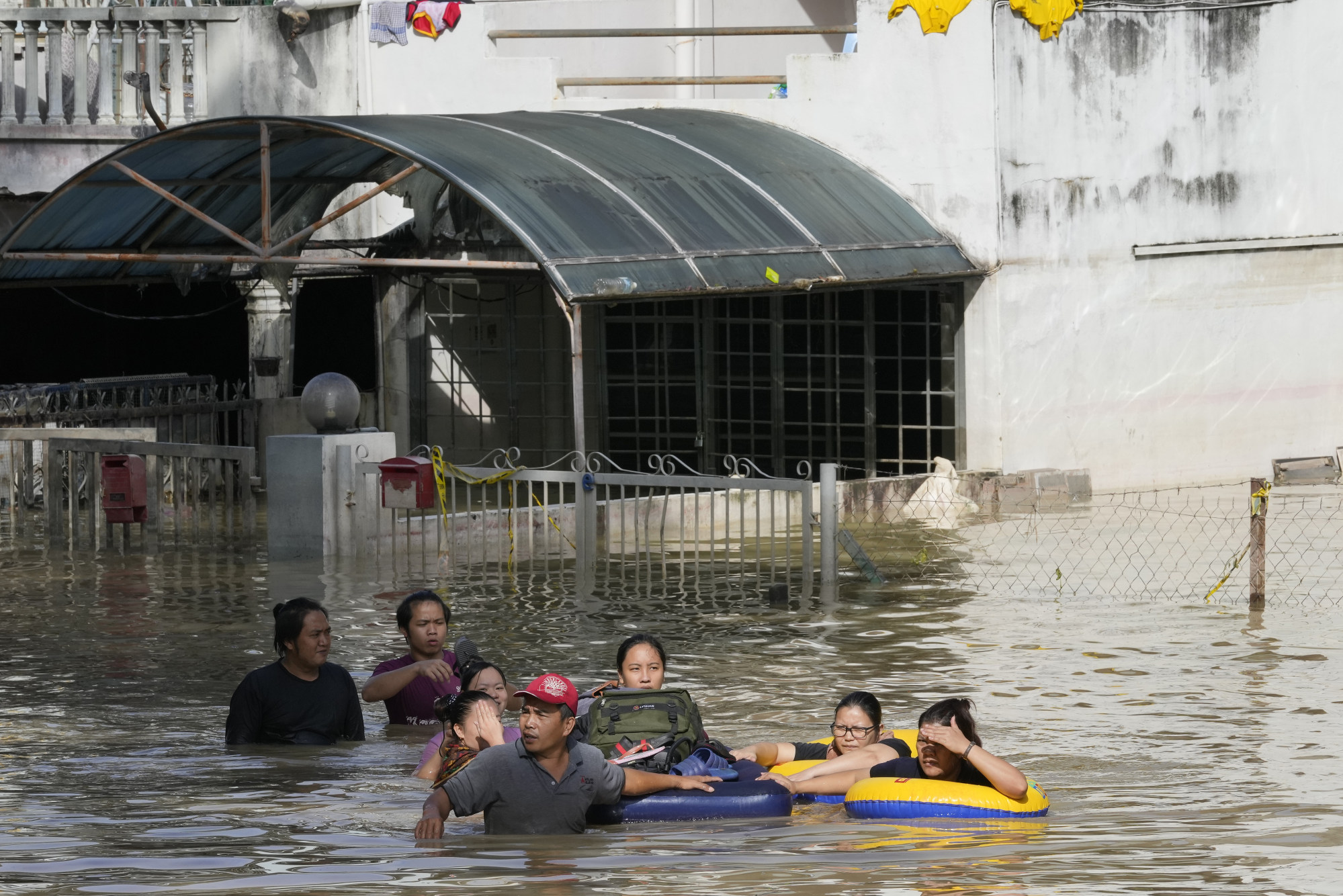 Residents wade through a flooded road on the outskirts of Kuala Lumpur in 2021. Extreme weather is becoming more intense and frequent because of climate change. Photo: AP