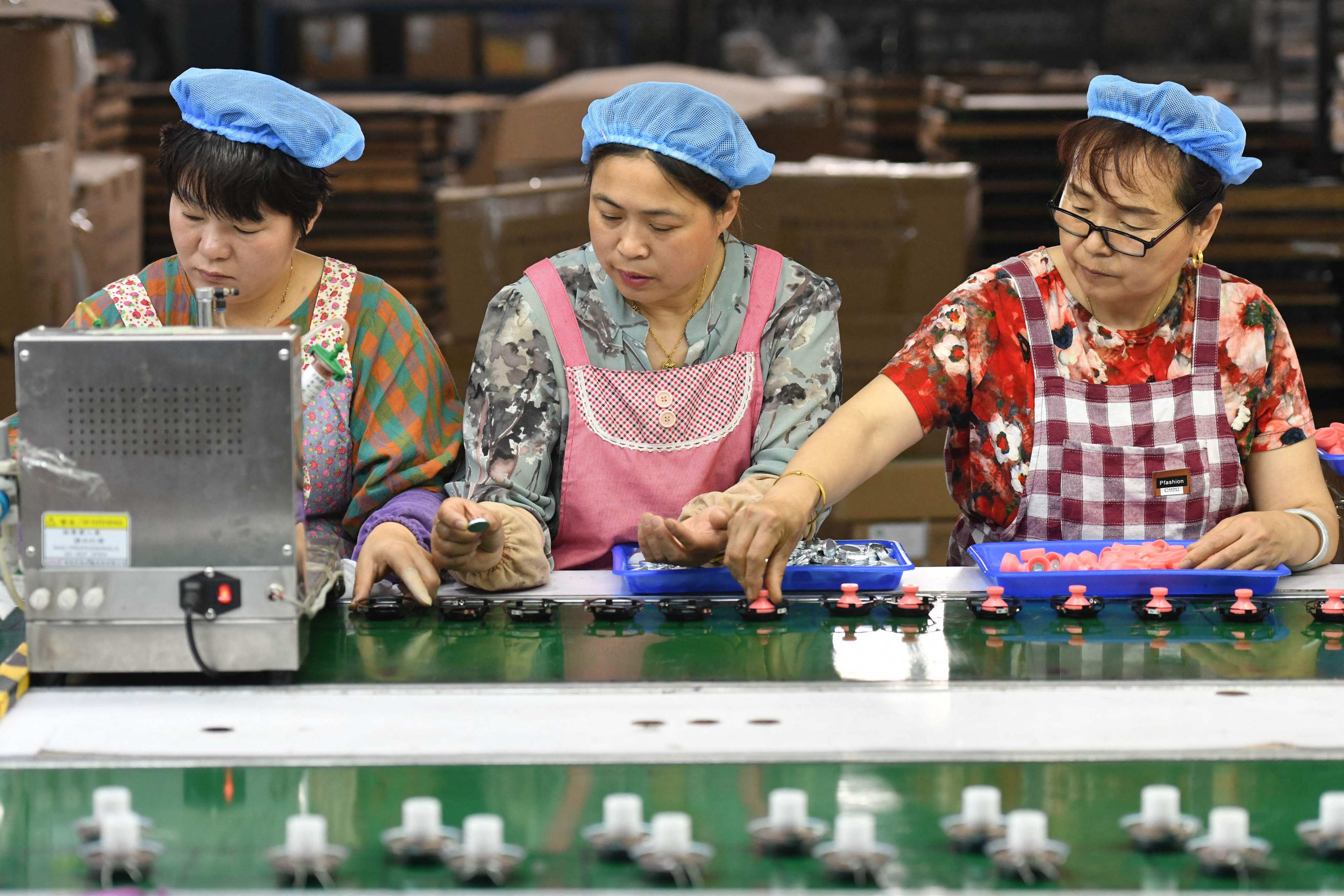 Employees work on an assembly line producing speakers at a factory in Fuyang, in China’s eastern Anhui province, May 31, 2023. Photo: AFP