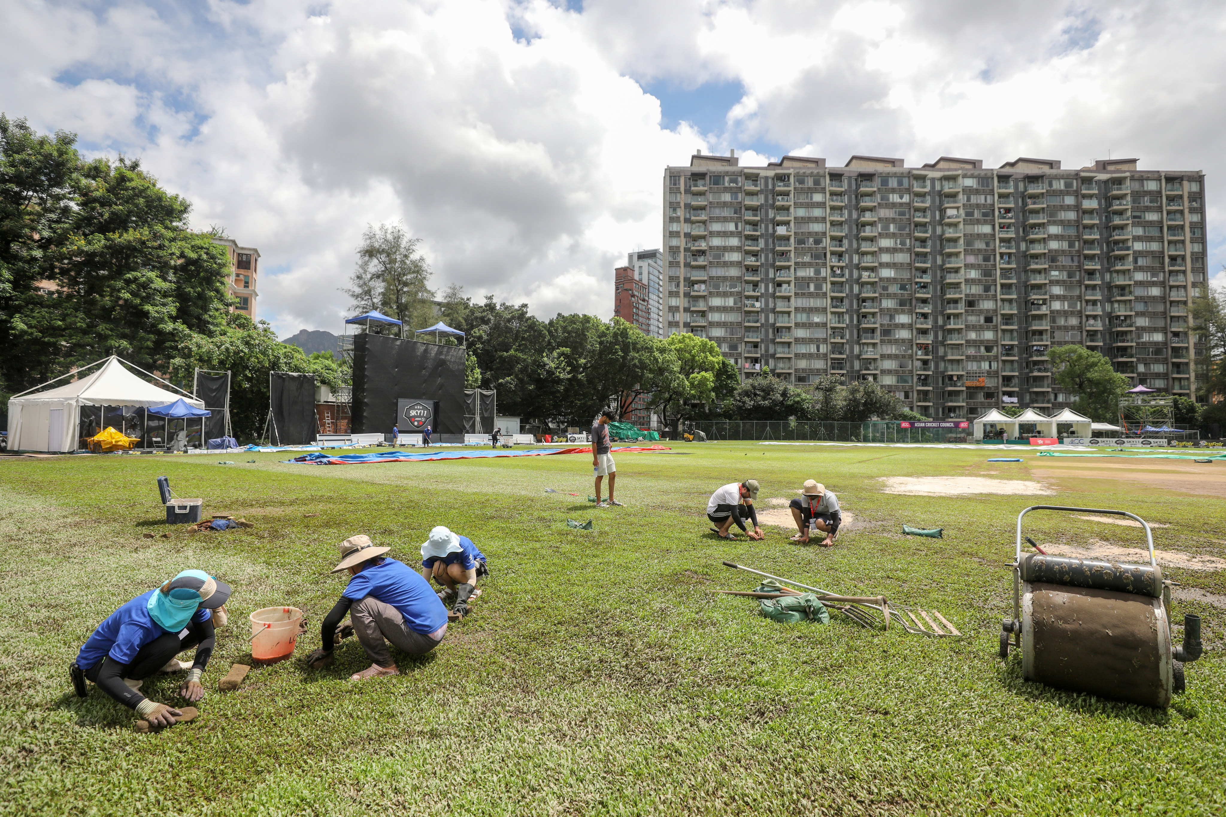 Workers try to dry the outfield at Tin Kwon Road Recreation Ground with sponges after days of heavy rain. Photo: Xiaomei Chen