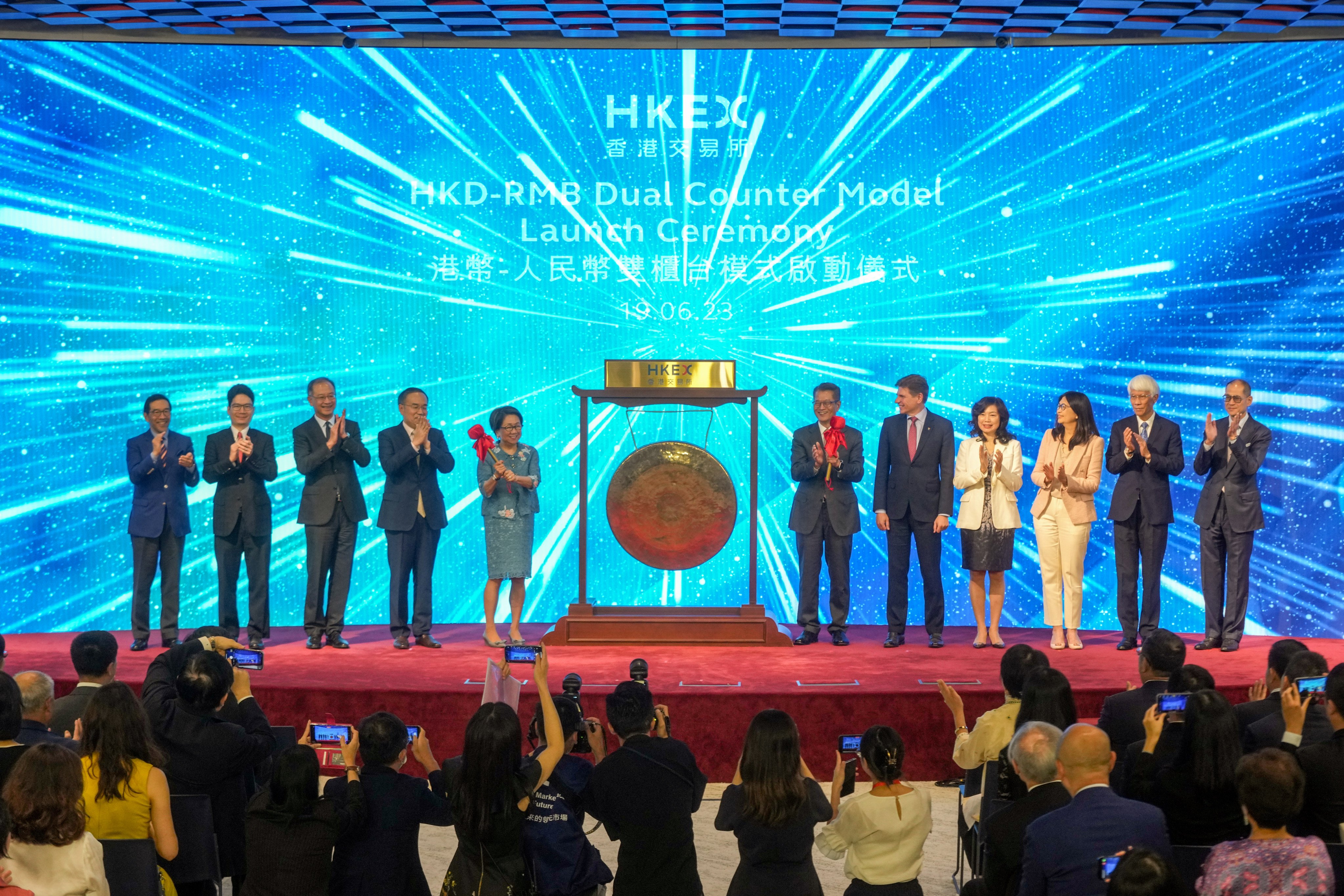 Hong Kong’s Financial Secretary Paul Chan Mo-po (sixth right) and HKEX’s chairwoman Laura Cha (fifth left) at the ceremony to launch the Dual Currency Model on the Hong Kong stock exchange on June 19, 2023. Photo: Sam Tsang