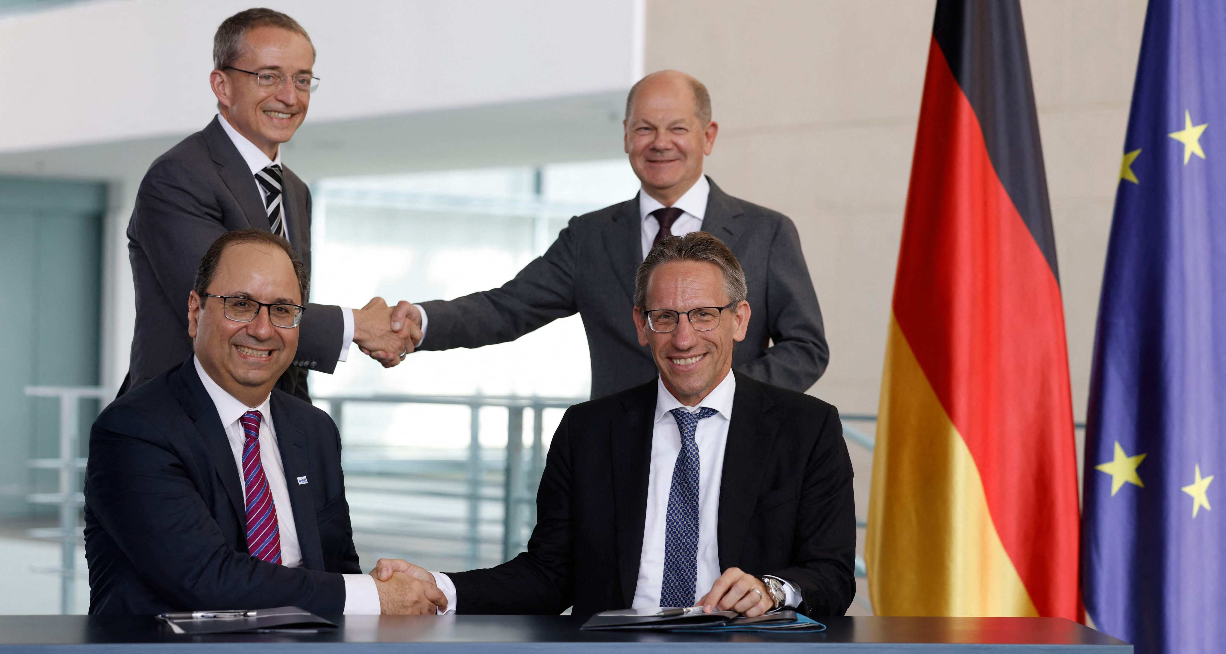 German Chancellor Olaf Scholz (background, right) shakes hands with Pat Gelsinger (background, left), CEO of US multinational corporation and technology company Intel, as State Secretary at the Chancellery Joerg Kukies (foreground, right) and Intel executive vice-president Keyvan Esfarjani (foreground, left) also shake hands after signing an agreement between the German government and Intel on June 19, 2023 at the Chancellery in Berlin. Photo: AFP