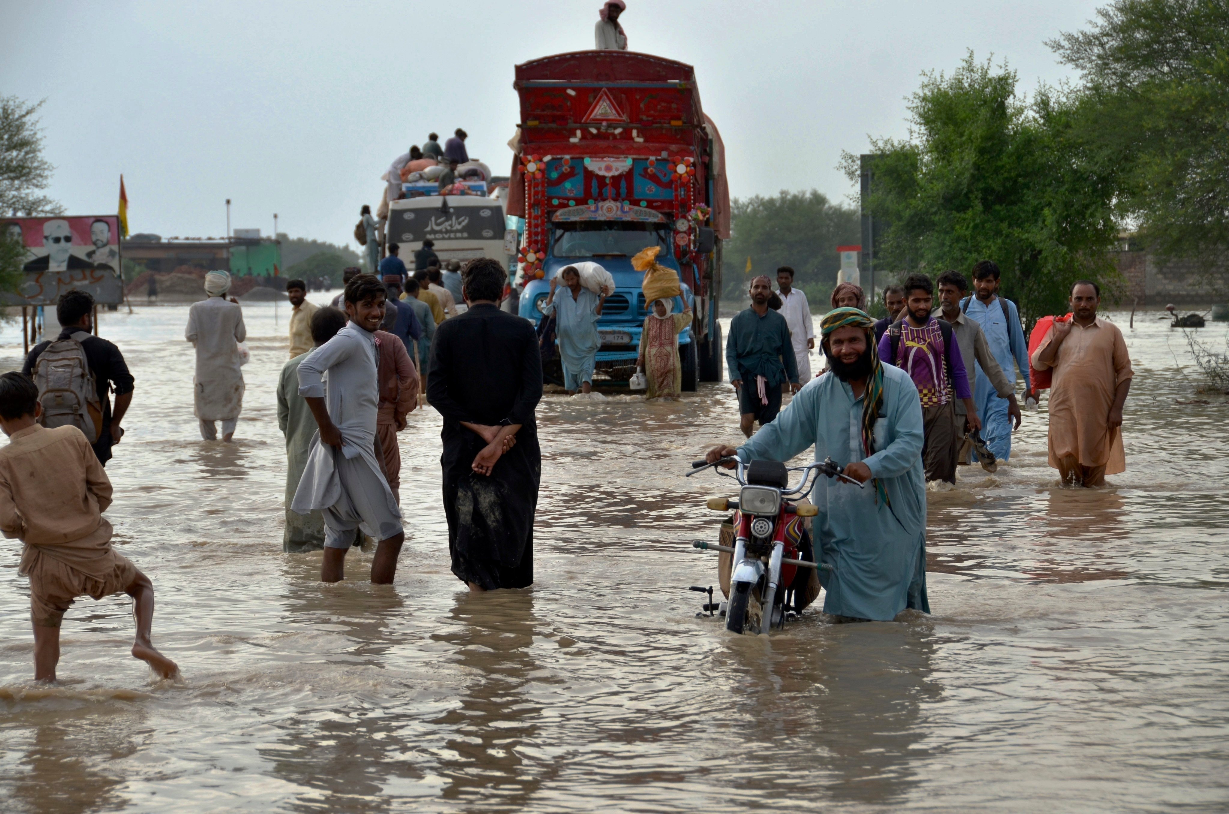 People navigate through a flooded road after heavy monsoon rains in Nasirabad, in Pakistan’s southwestern Baluchistan province, on August 22, 2022. Developing countries need the help of the developed world to mitigate the effects of disasters driven by climate change. Photo: AP