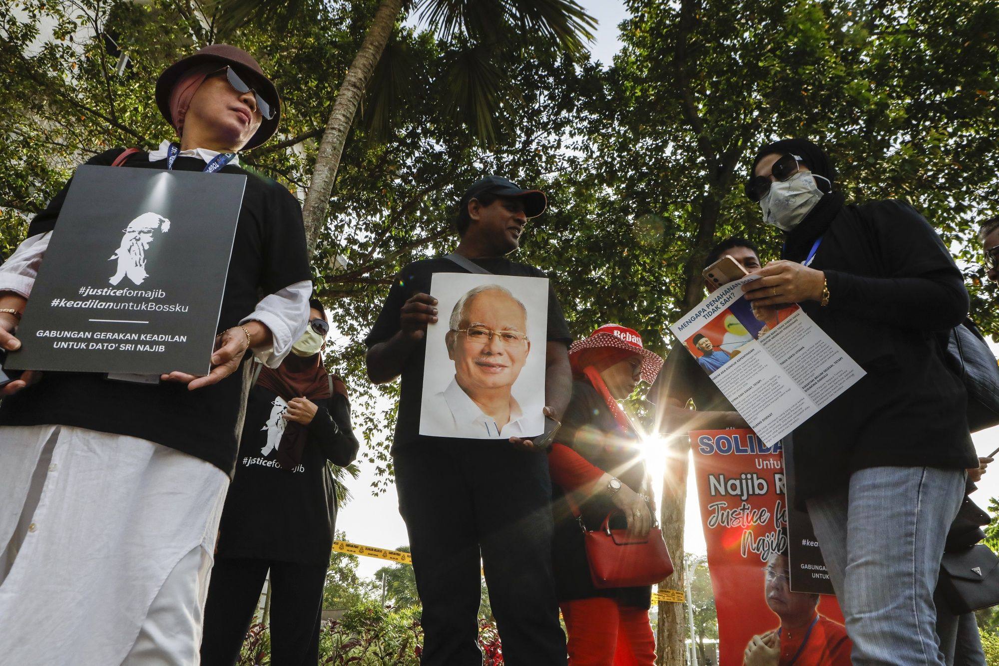 Supporters of former Prime Minister Najib Razak hold placards outside a court of appeal in Putrajaya ahead of an appeal hearing earlier this year. Grass-roots members of the parties in Anwar’s unity government have a hard time playing nice with their long-time rivals, analysts say. Photo: Bloomberg