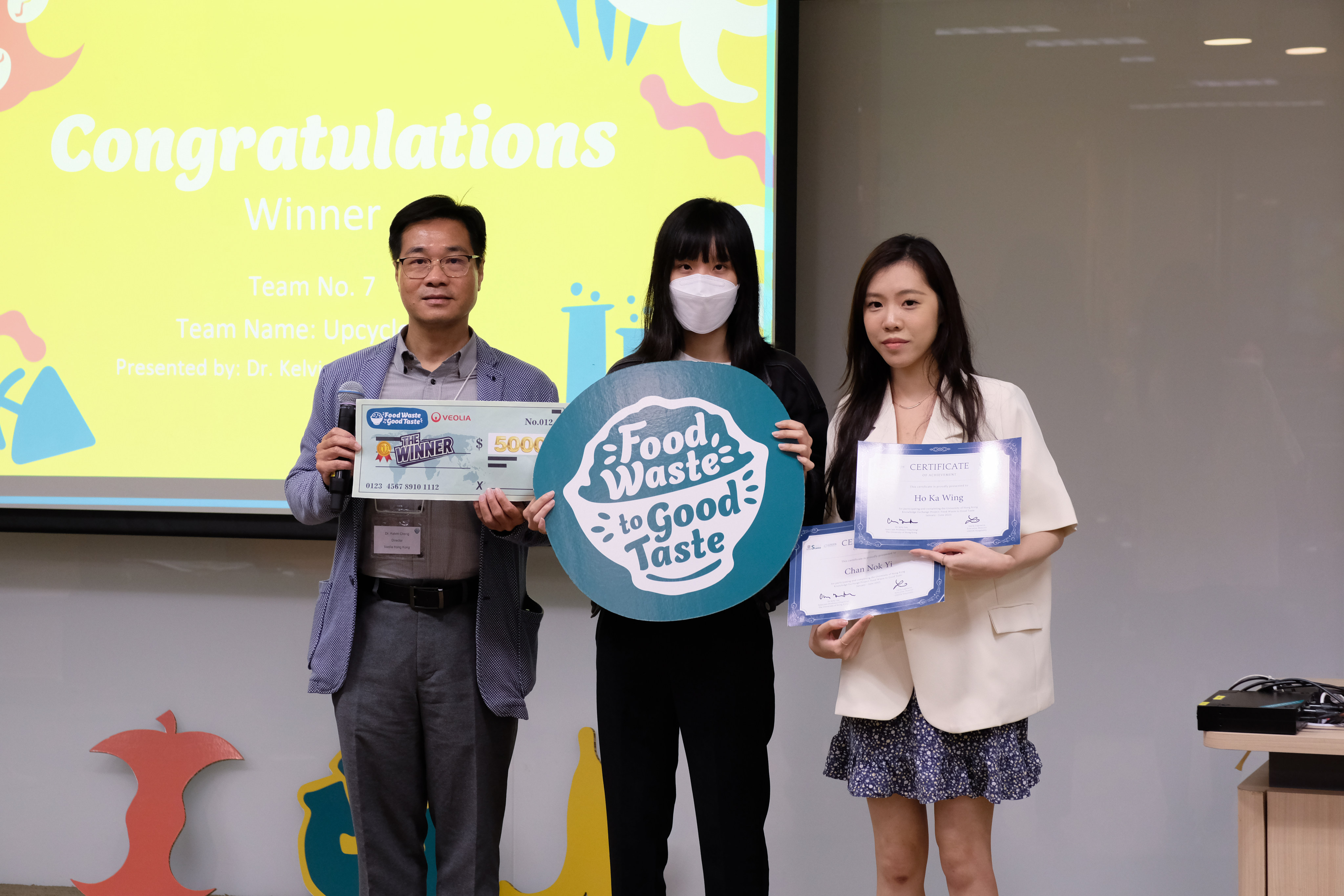 Dr. Kelvin Cheng, Director of Veolia Hong Kong, presents the first-place award to the winners of the innovation competition, Anson Chan Nok-yi and Gloria Ho Ka-wing. Photo: Erika Makino/Colin Wu