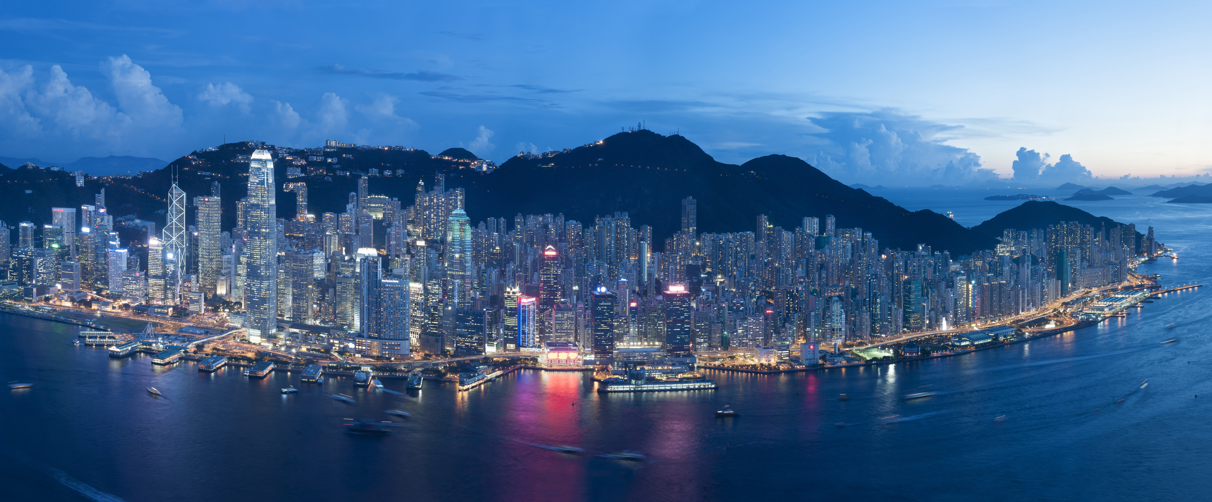 Hong Kong’s iconic skyline as seen at dusk, with skyscrapers lit up against a mountainous backdrop. Photo: Shutterstock
