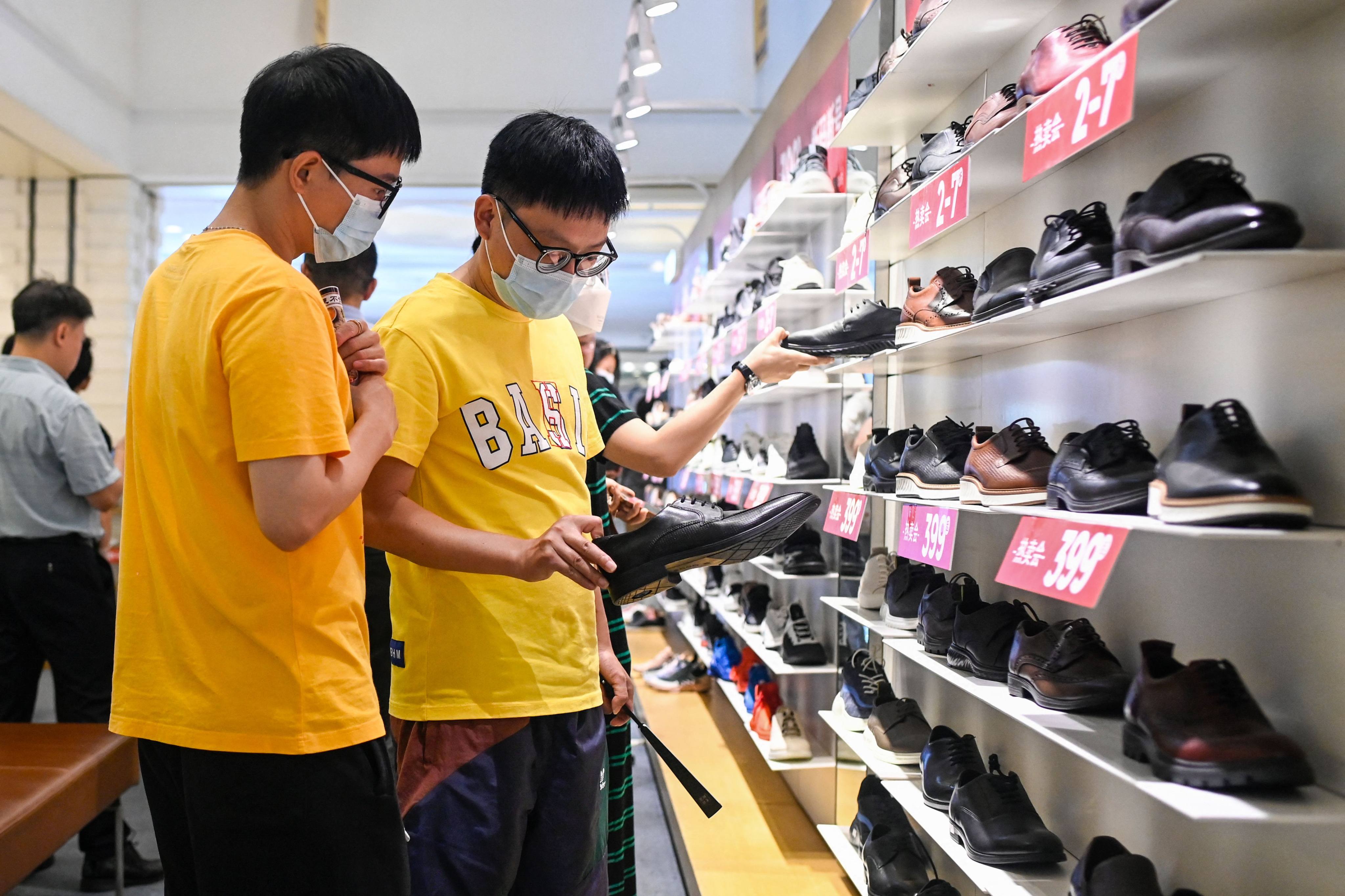 Shoppers look at shoes in a Beijing mall on June 15. Analysts are concerned about an uneven economic recovery in China, with consumer confidence taking a hit from income and job uncertainties. Photo: AFP