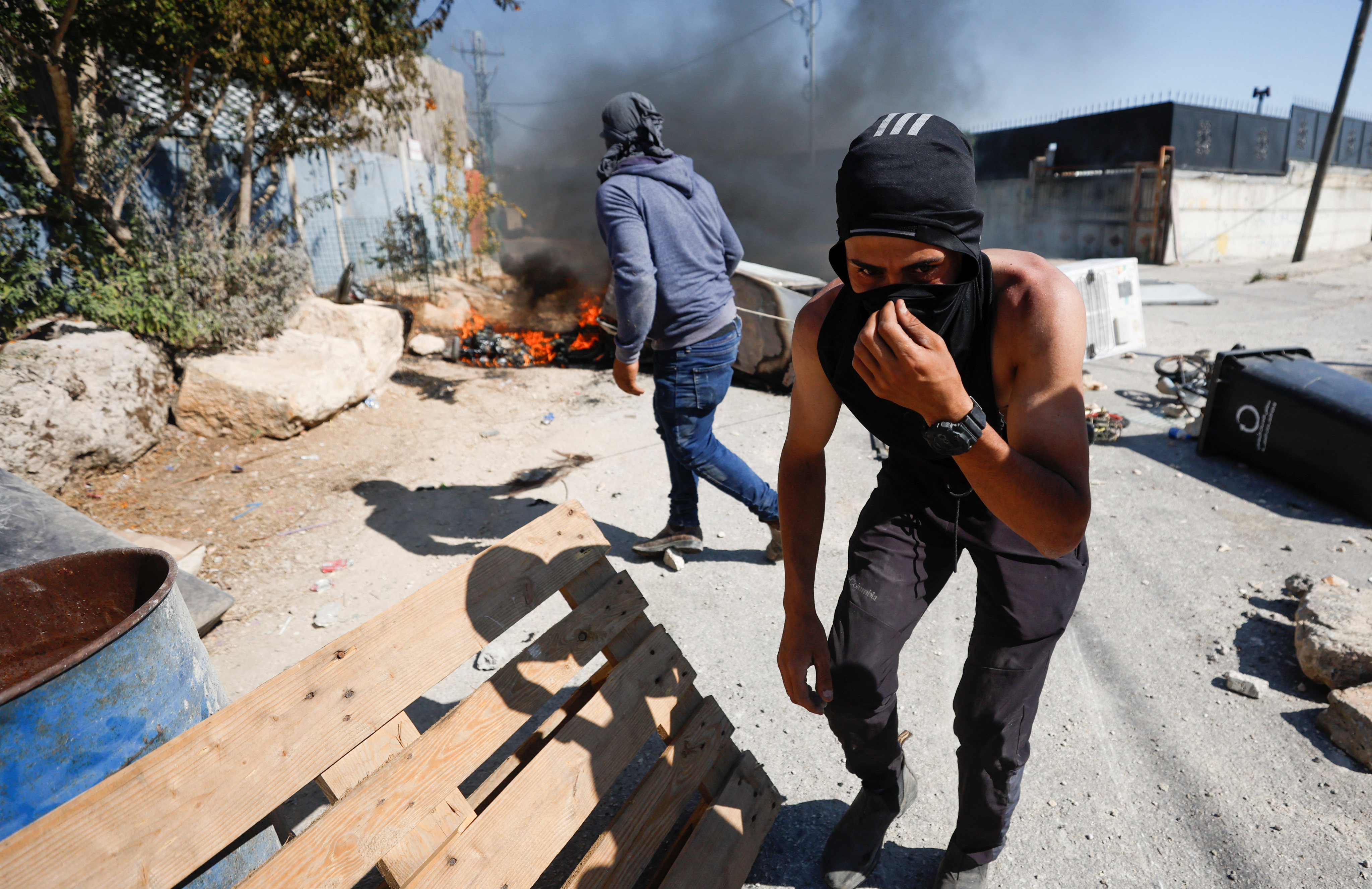 A Palestinian covers his face during clashes with Israeli troops after Israeli settlers attack Umm Safa village near Ramallah, in the Israeli-occupied West Bank, on Saturday. Photo: Reuters