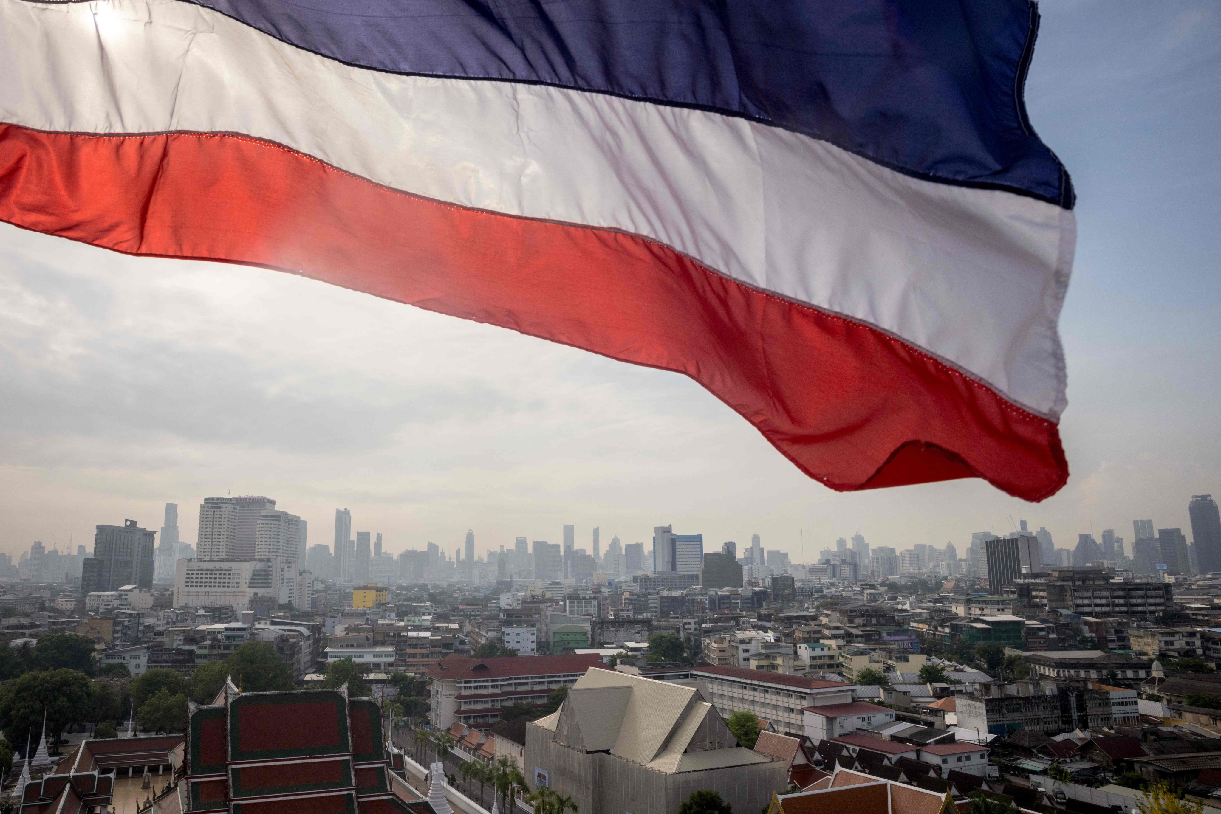The flag of Thailand flies over Bangkok. Minimum wages in Thailand are poised to increase after the Move Forward Party swept last month’s elections. Photo: AFP