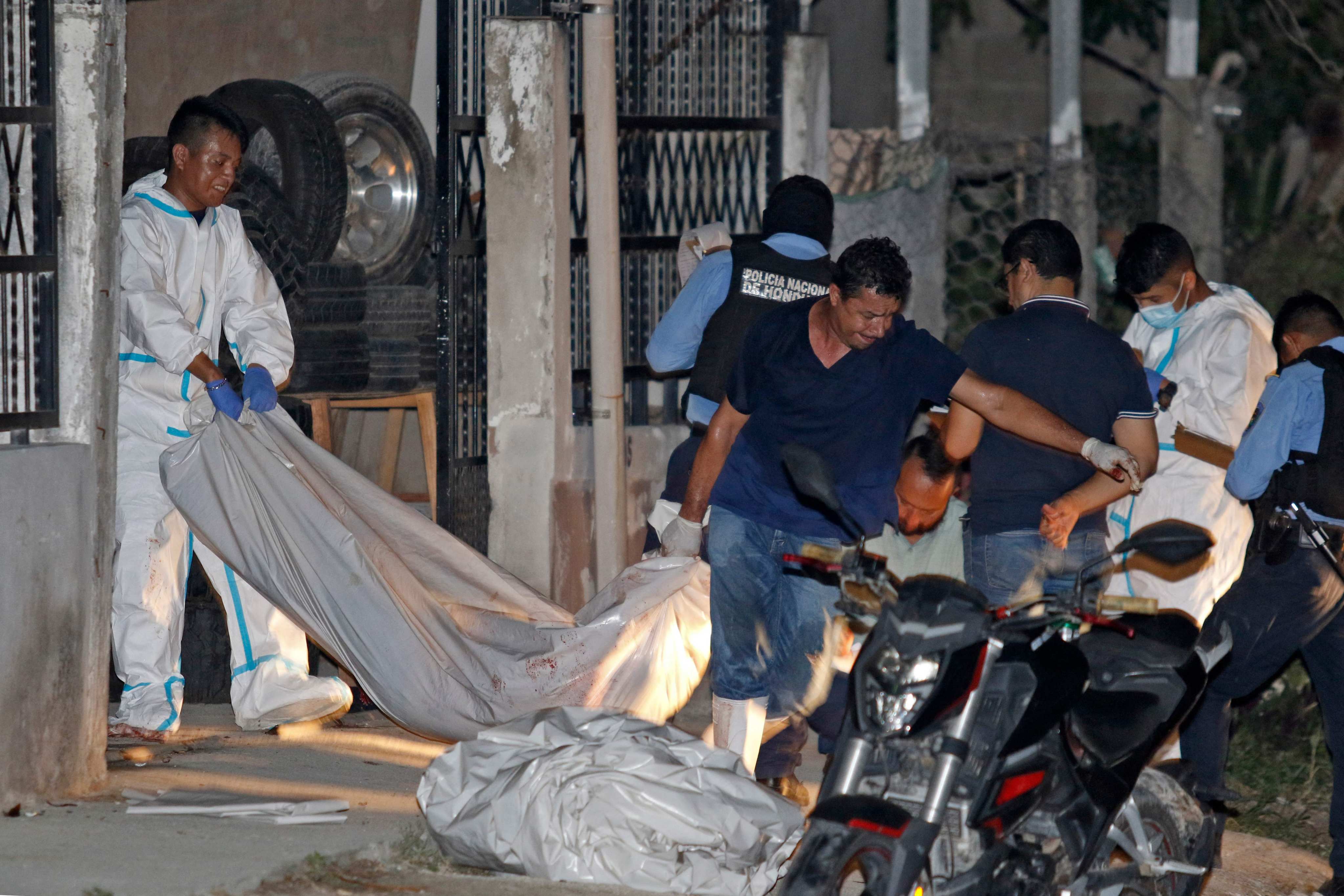 Forensic staff remove the body of one of the 11 people killed in a pool hall in Choloma, Cortes province, Honduras on Sunday. Photo: AFP