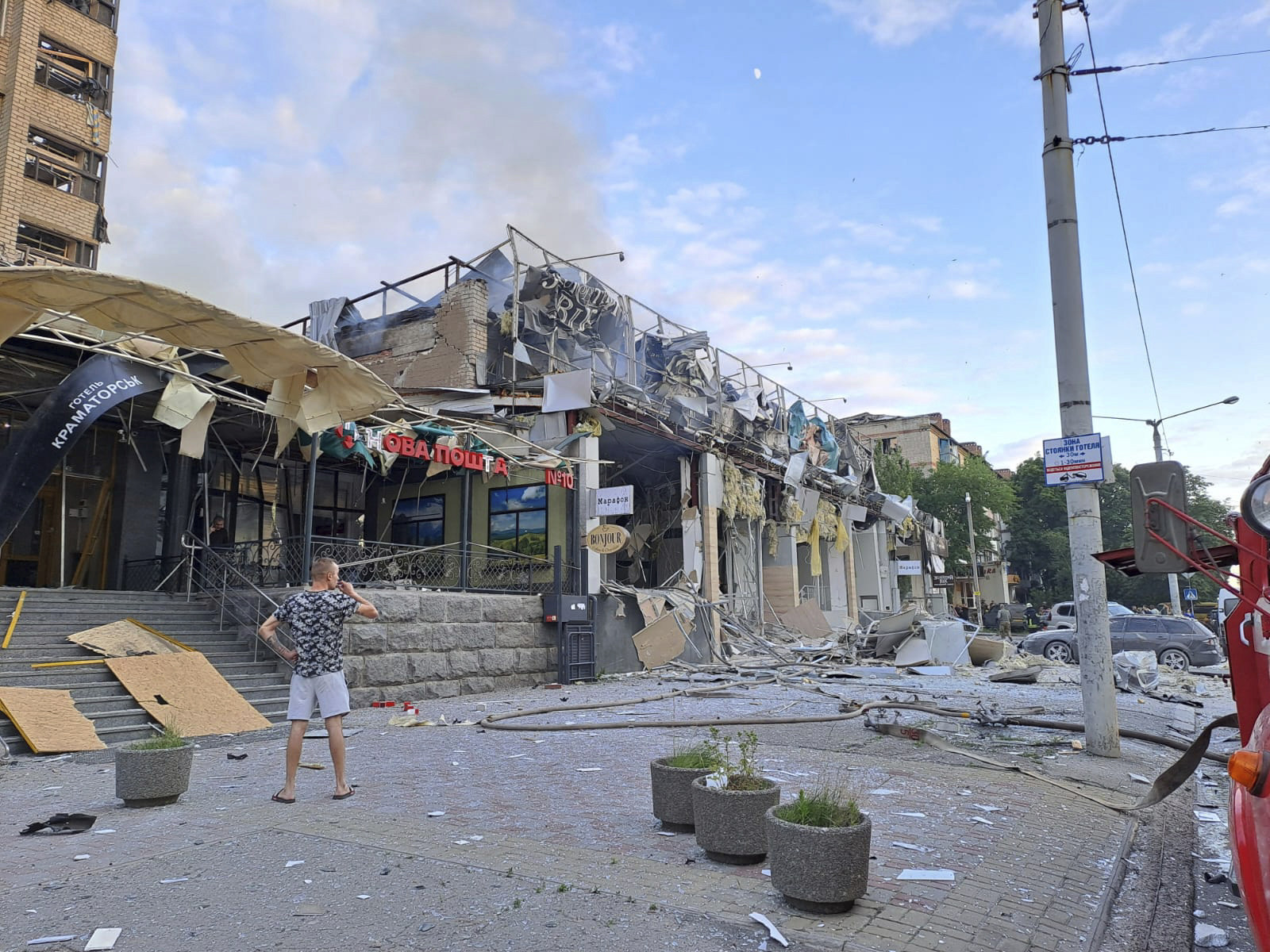 A man stands on a street in front of a shop and pizza restaurant destroyed by a Russian attack in Kramatorsk. Photo: via AP