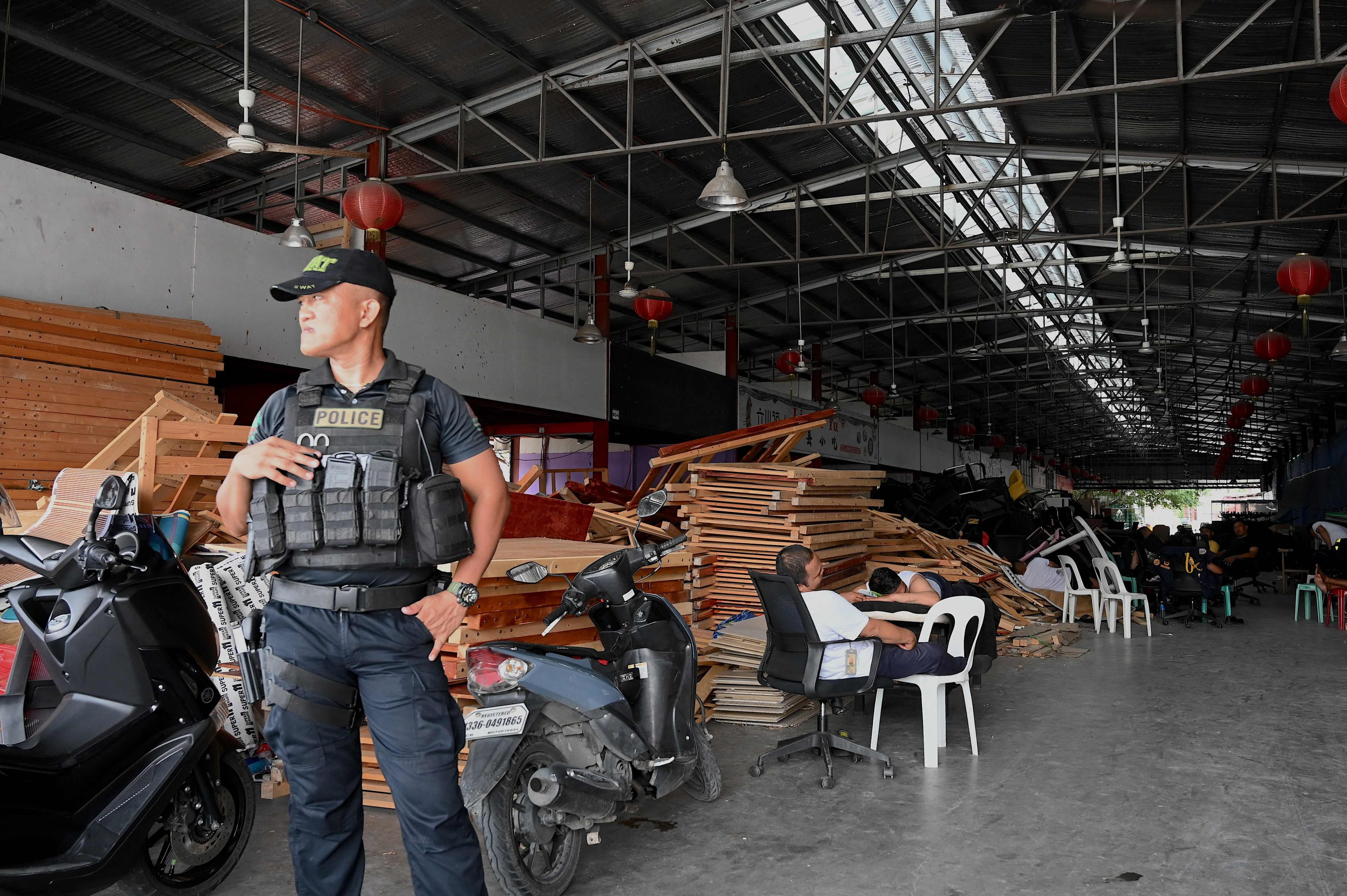 A policeman stands guard inside a compound in Las Pinas city, Metro Manila, following Tuesday’s massive nighttime raid. Photo: AFP