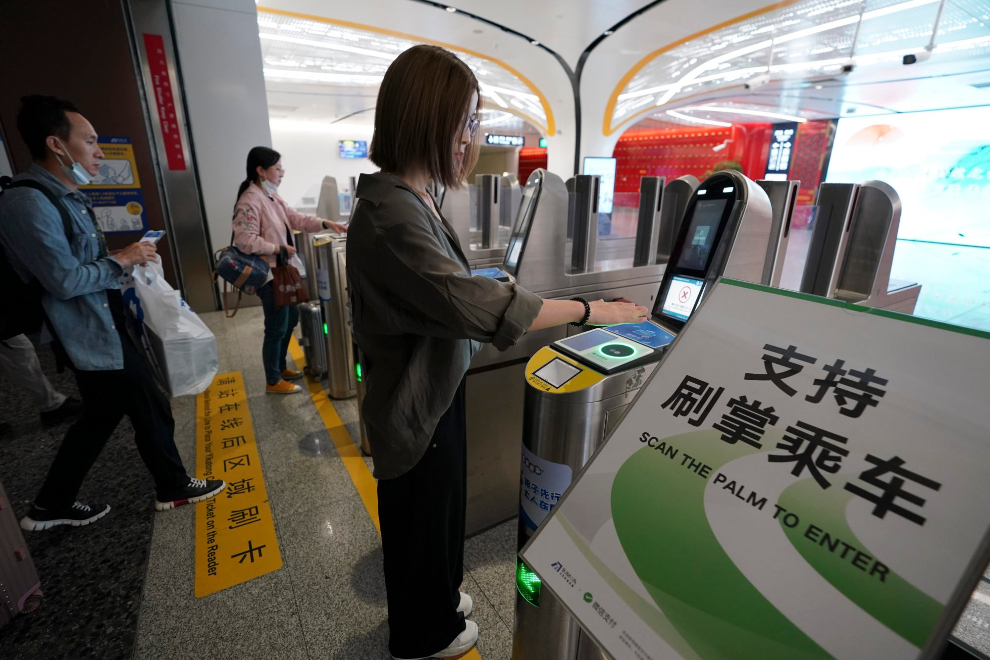 A passenger shows her palm to pass through a ticket gate at a station on the Daxing Airport Express, a Beijing subway line. Photo: Beijing Youth Daily/VCG via Getty Images
