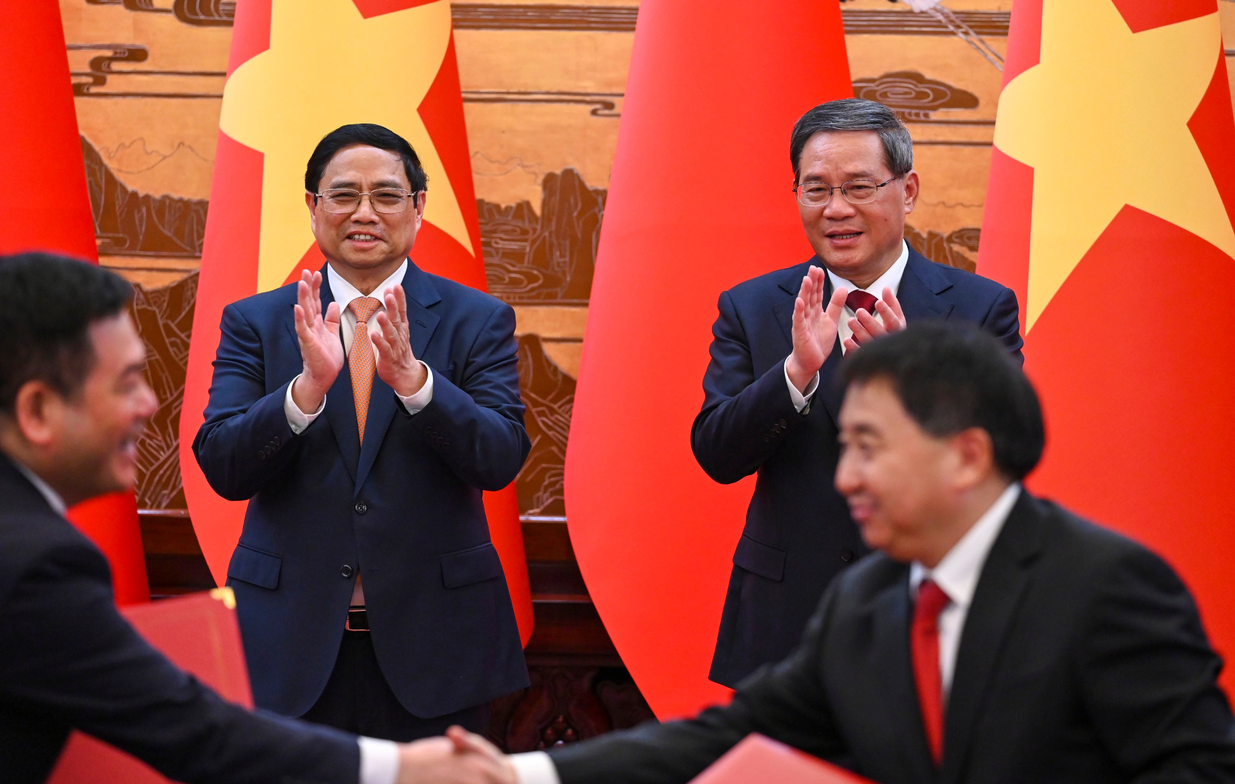 Vietnam’s Prime Minister Pham Minh Chinh (left) and Chinese Premier Li Qiang applaud the signing of an agreement at the Great Hall of the People in Beijing on Monday.  Photo: EPA-EFE