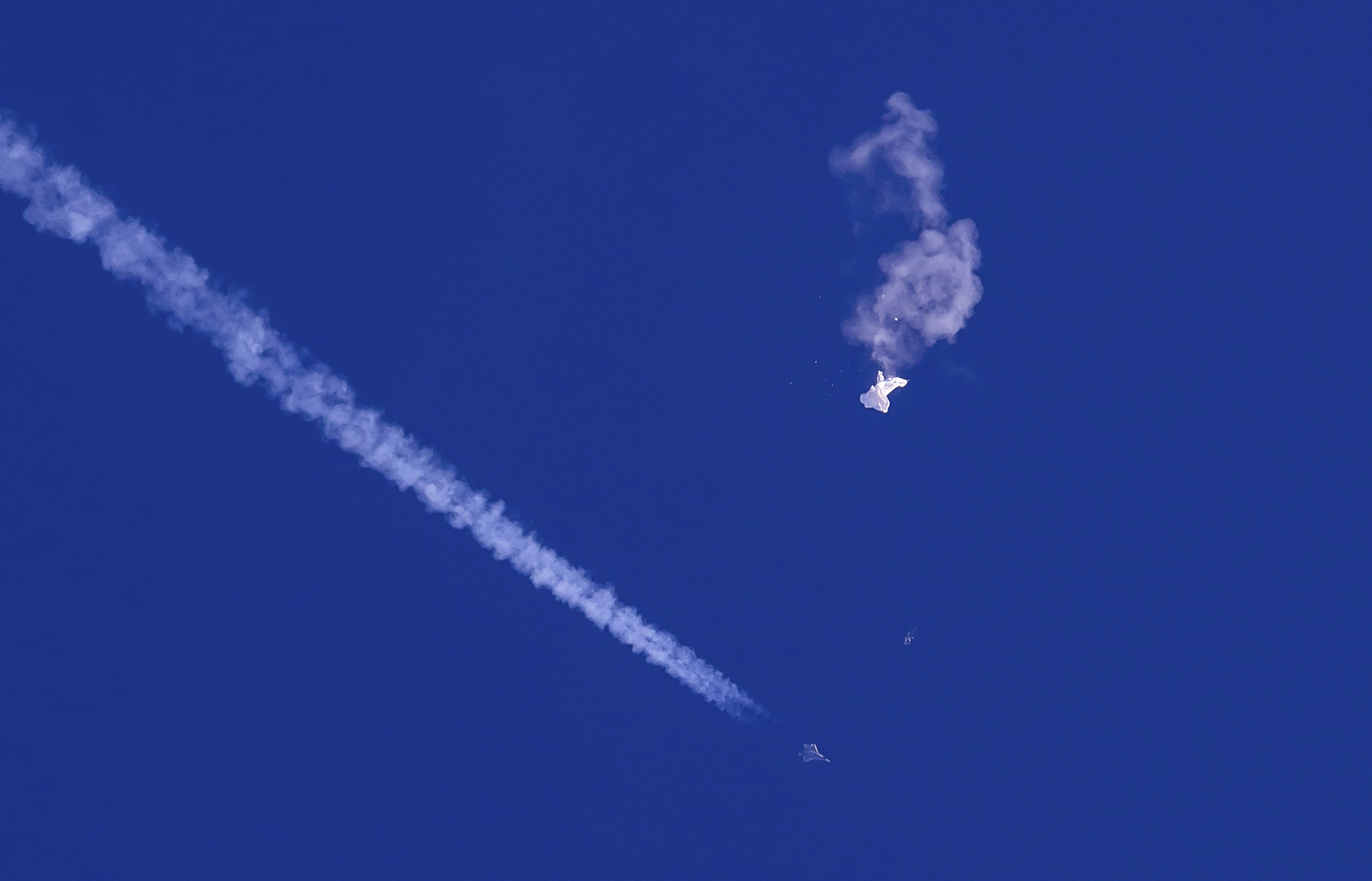 A fighter jet flies past the remnants of a large balloon after it was shot down over the Atlantic Ocean, off the coast of South Carolina, on February 4. Photo: AP