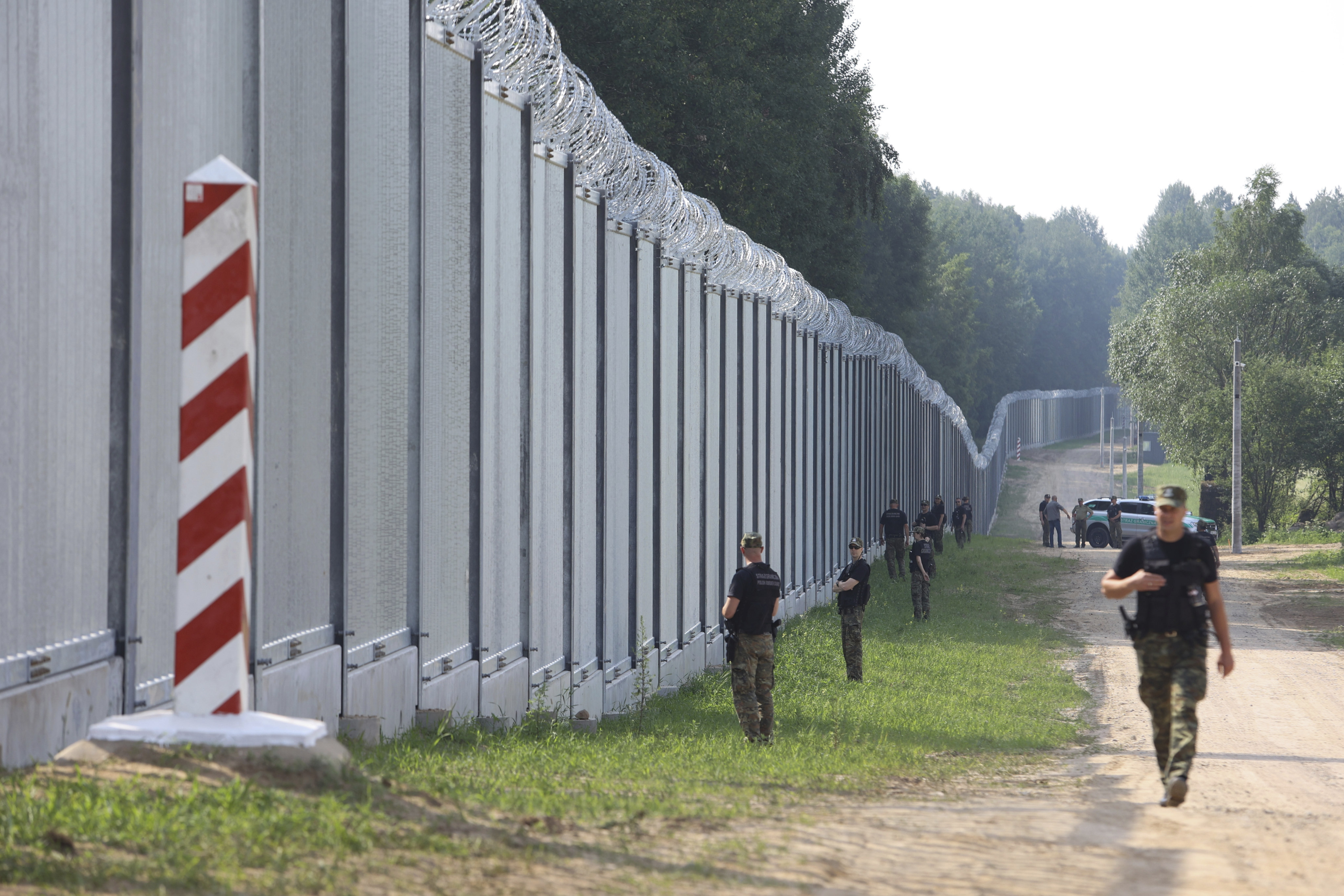 Polish guards patrol by a newly-built metal wall on the border between Poland and Belarus in 2022. Photo: AP