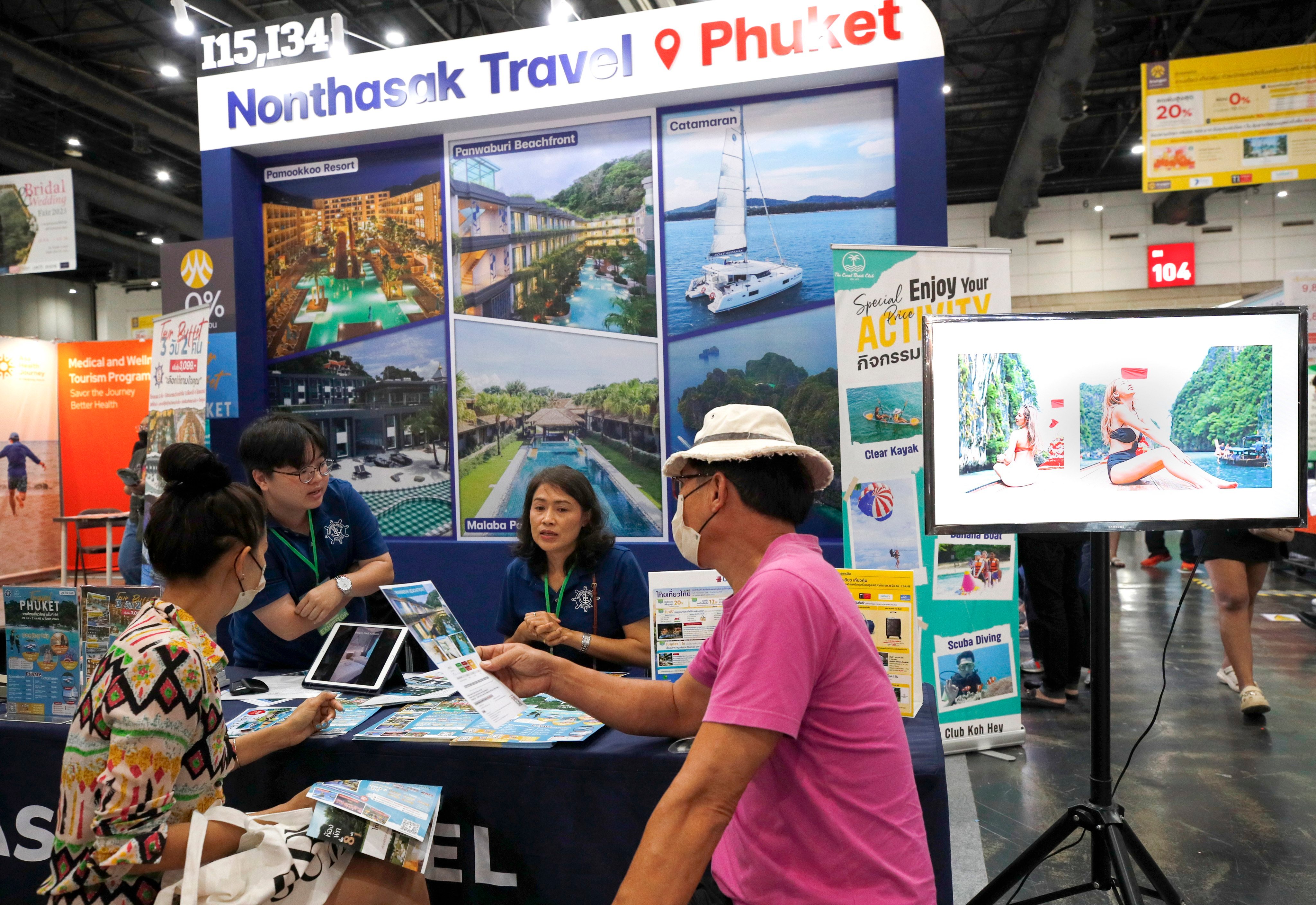 Visitors check travel deals at a travel and tourism fair in Bangkok on June 29. The tourism and travel fair featured hundreds of exhibitors from tour operators, hotels and travel agencies offering discounts in an attempt to revive the country’s tourism industry and boost its economy. Photo: EPA-EFE