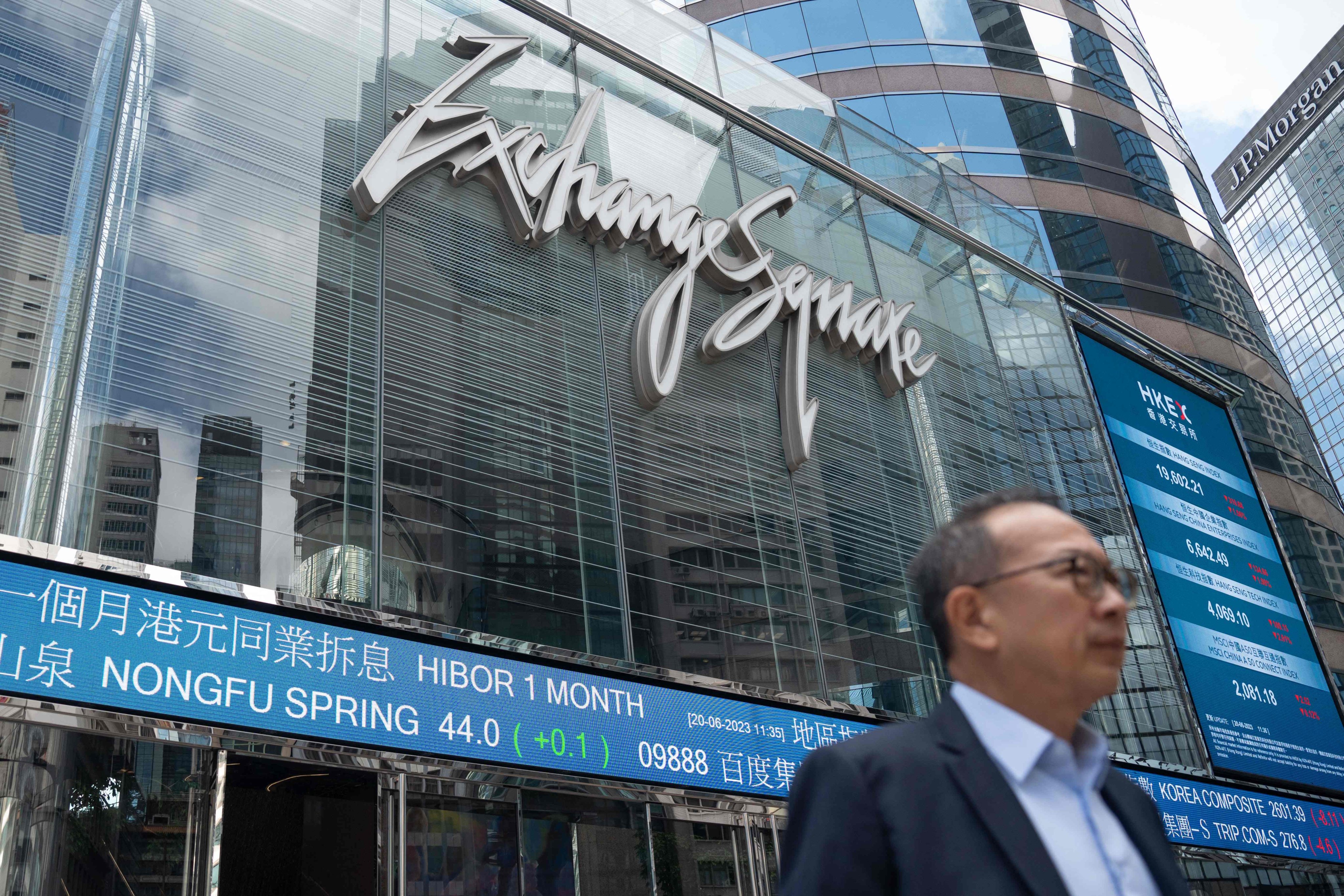 A man walks past an electronic sign showing stocks at Exchange Square in Hong Kong on June 20. Photo: AFP