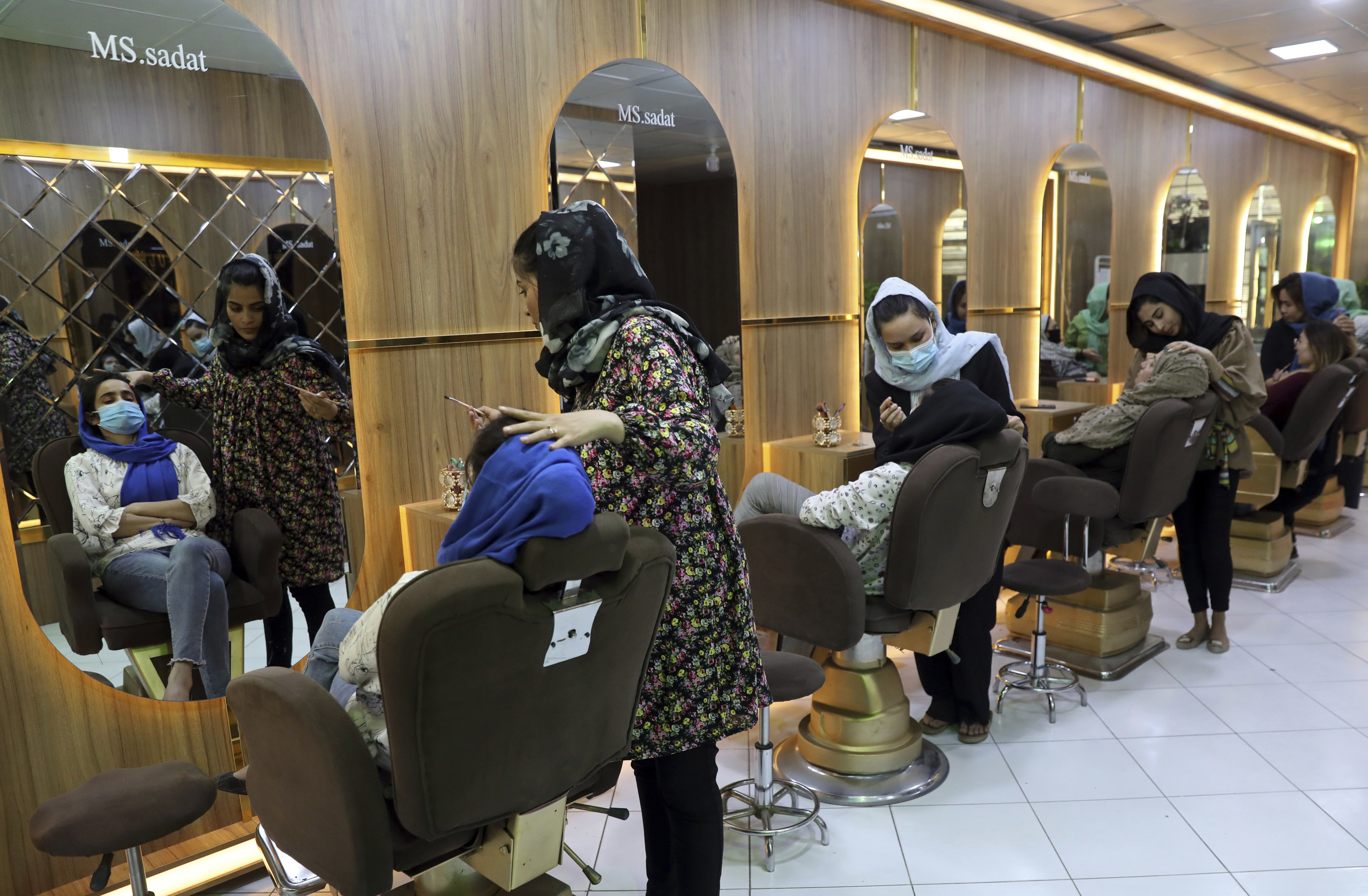 Beauticians put make-up on customers at a salon in Kabul on April 25, 2021. Photo: AP