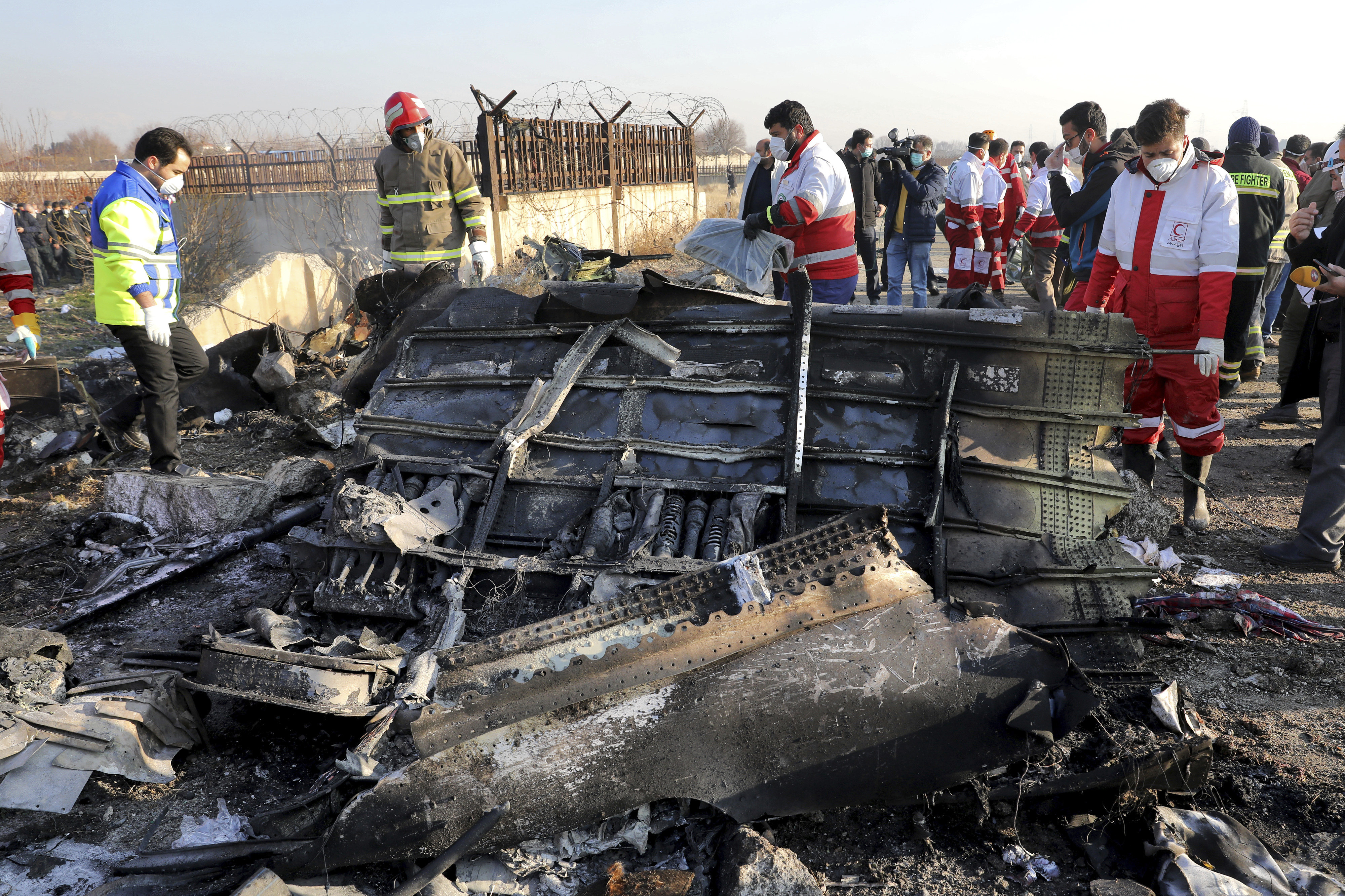 Rescue workers search the scene of a downed Ukrainian jetliner that crashed outside Tehran. Photo: AP