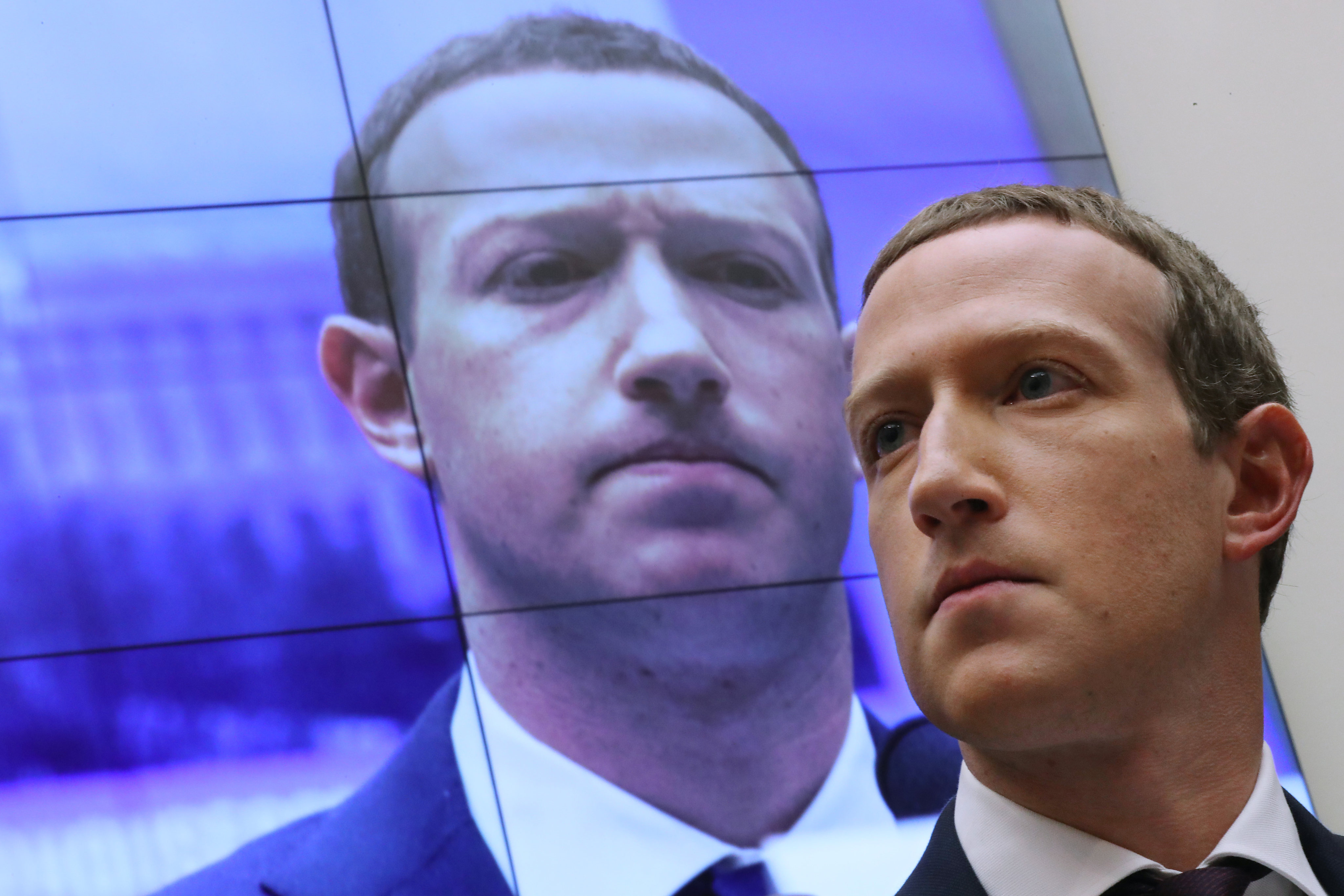 With an image of himself on a screen in the background, Mark Zuckerberg testifies before the House Financial Services Committee on Capitol Hill in 2019. Photo: Getty Images/TNS