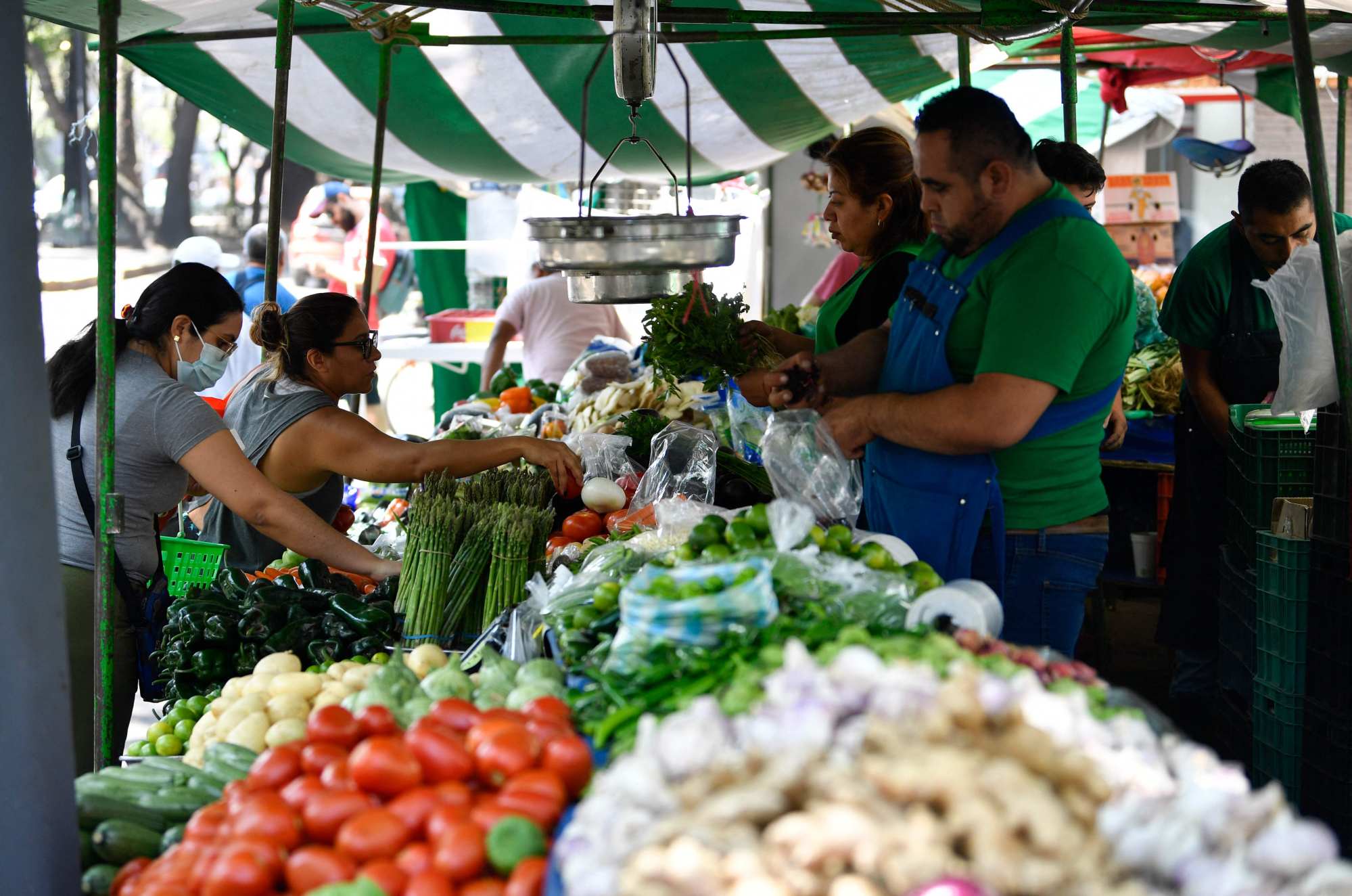 People buy and sell at a local market in Mexico City on June 23. The Mexican peso has appreciated by 13.45 per cent against the US dollar in 2023. This appreciation has led to people receiving money from the United States obtaining fewer pesos when withdrawing it in Mexico because of the strength of the local currency. While it benefits importers, this situation affects 4.6 million households in Mexico that depend on remittances as their main source of foreign exchange. Photo: AFP