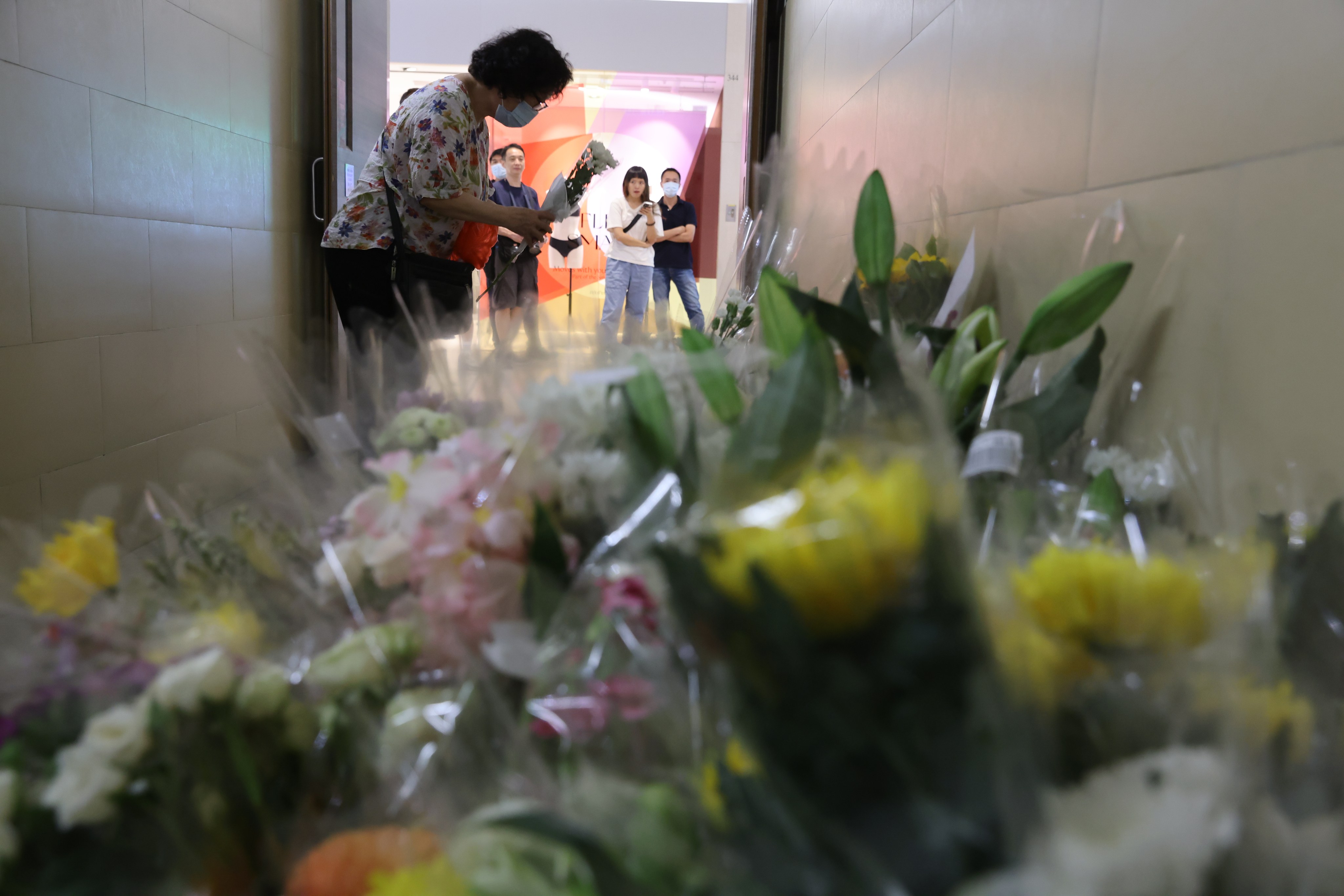 People place flowers at the scene where two women were stabbed to death at a Hong Kong shopping centre last month. Photo: May Tse
