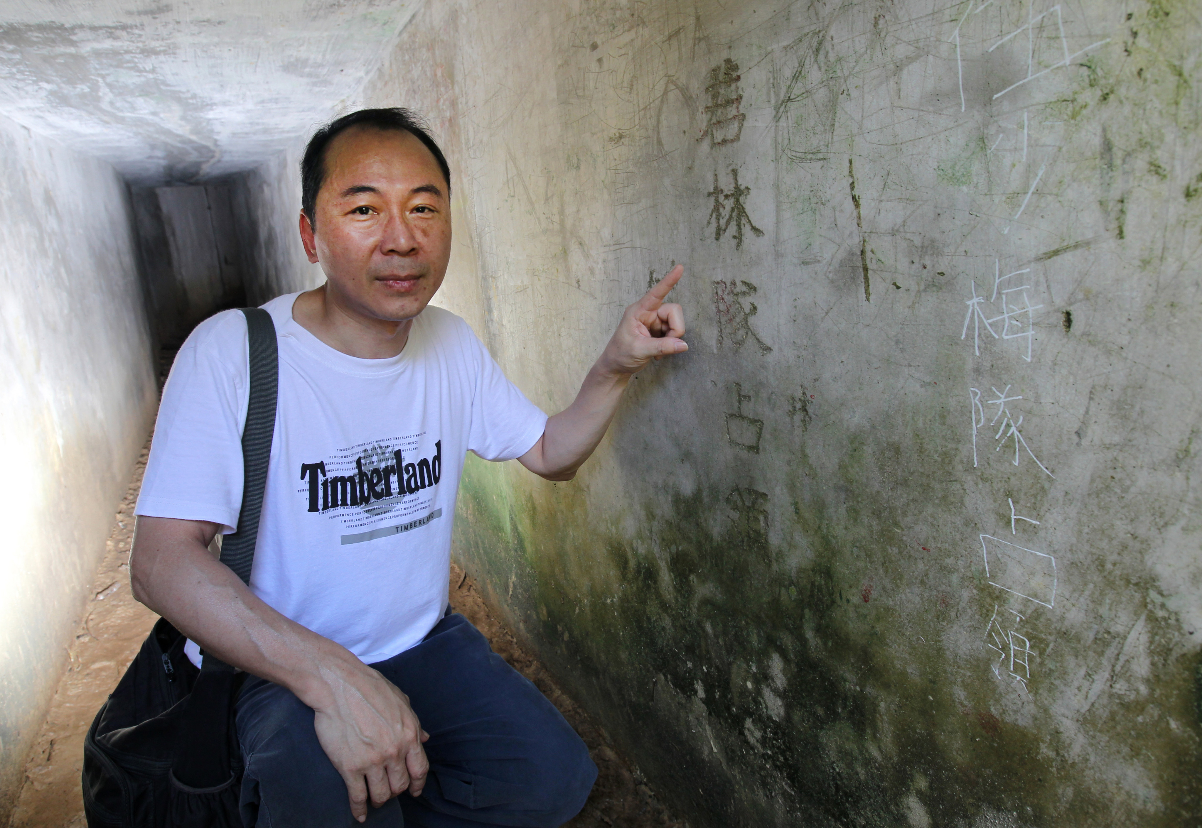 Ko Tim-keung, an expert in Hong Kong military history, shows a rare inscription left by the Japanese army in a tunnel of the Shing Mun Redoubt during the second world war. The inscriptions mark the name of a Japanese commander Wakabayashi Toichi, considered by Japanese as a war hero. But it is threatened by vandalism. Photo: Dickson Lee