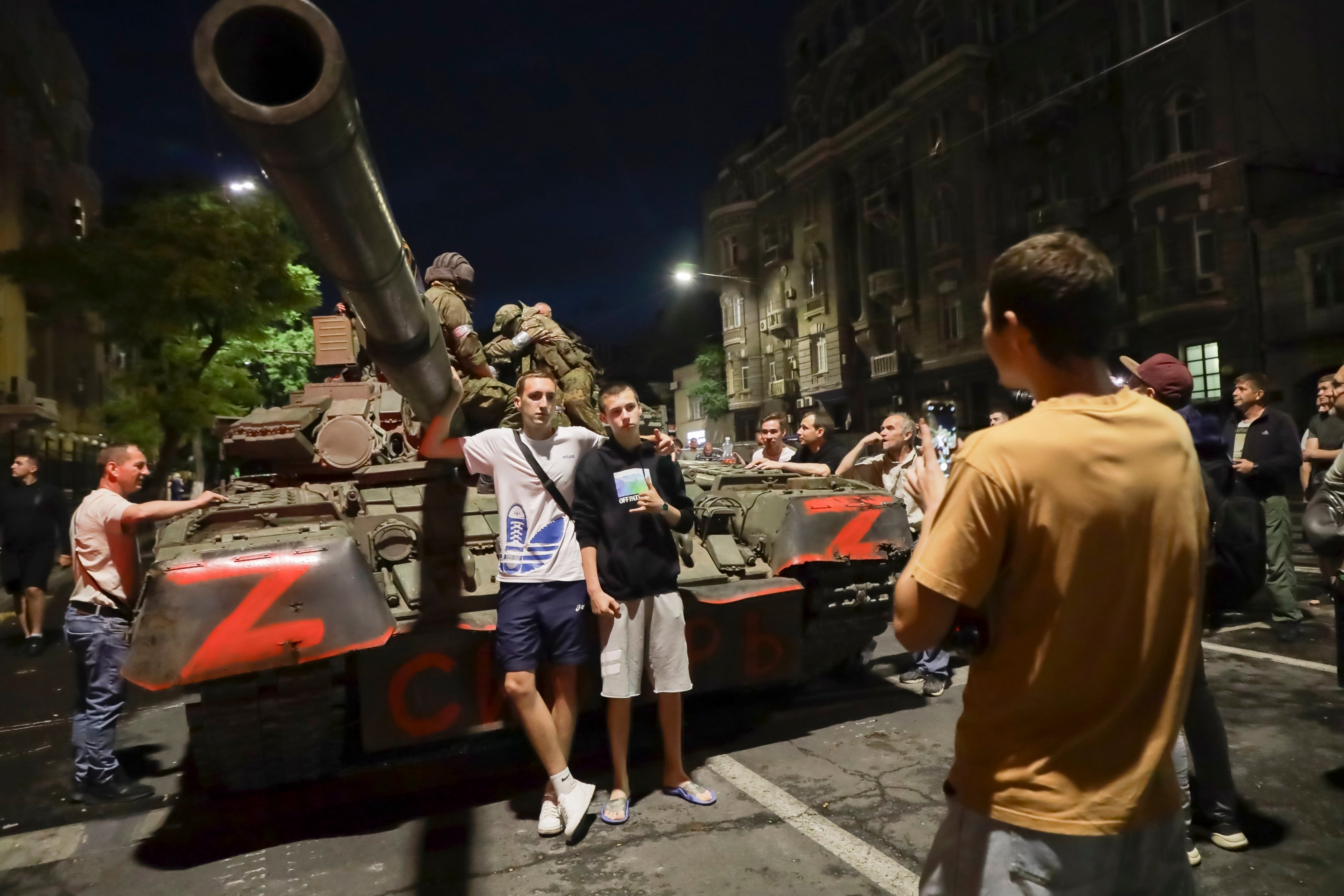 Wagner fighters sit atop a tank, as locals pose in front of it in Rostov-on-Don, Russia. Photo: AP