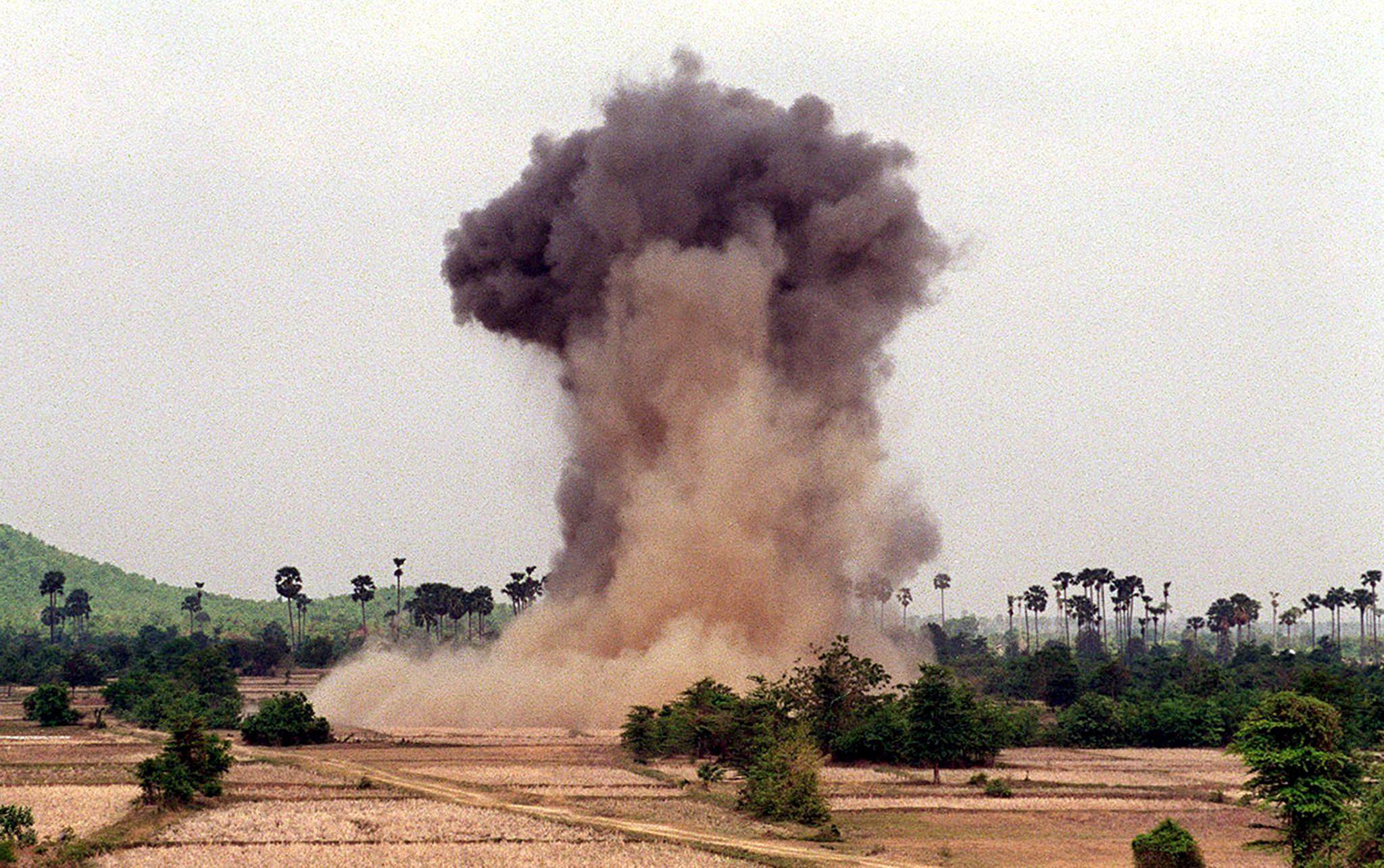 A cloud of dust and smoke rises from a cache of unexploded ordinance detonated by deminers in Cambodia in 2004. Photo: AFP
