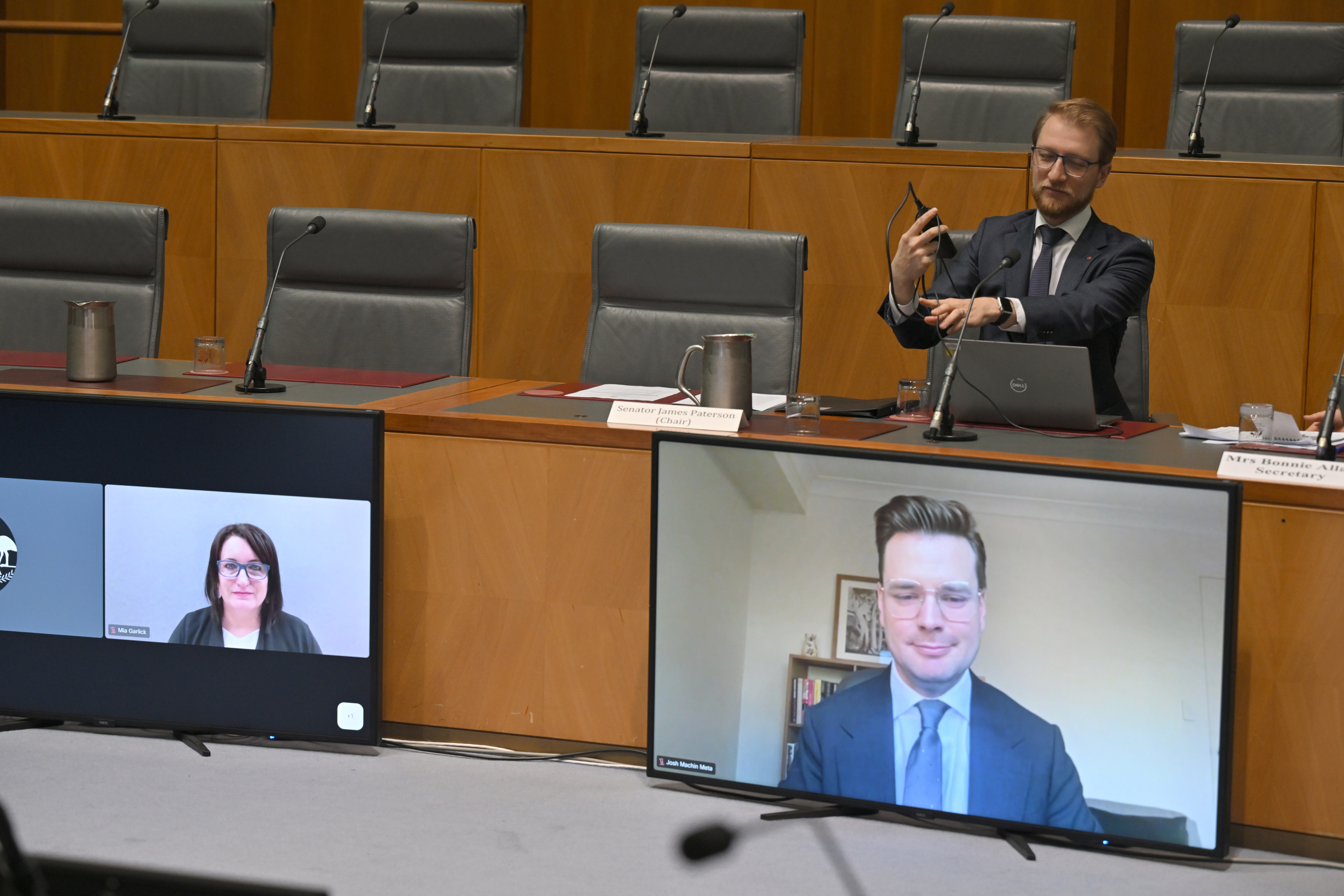 Meta’s Mia Garlick (left, on screen) and Josh Machin (right, on screen) at the Select Committee on Foreign Interference through Social Media at Parliament House in Canberra. Photo: AAP/dpa