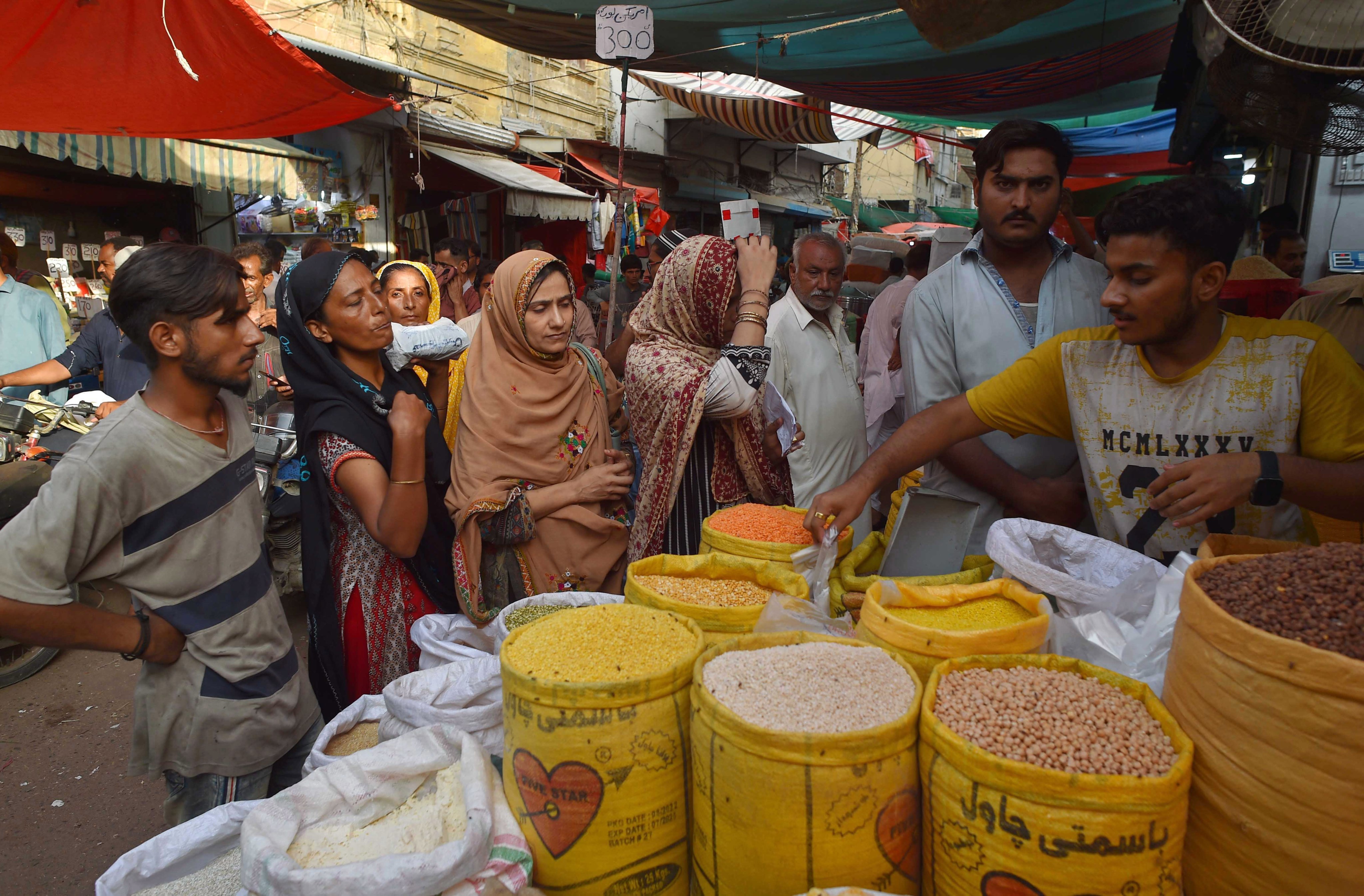 People buy groceries at a market in Karachi, Pakistan. The shortage in supplies in Pakistan was triggered by monsoon floods last year that submerged nearly a third of the country. Photo: EPA-EFE
