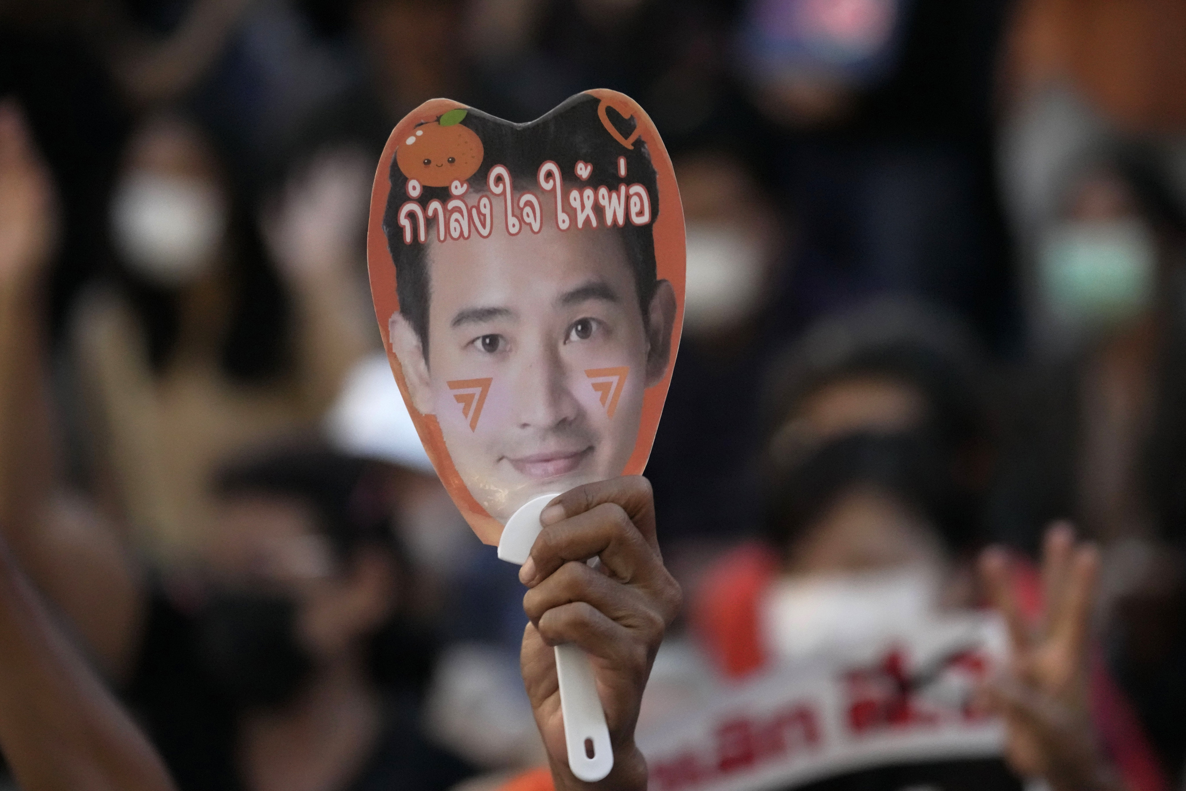 A supporter of the Move Forward Party holds a paper fan of Pita Limjaroenrat, the leader of the Move Forward Party. Photo: AP