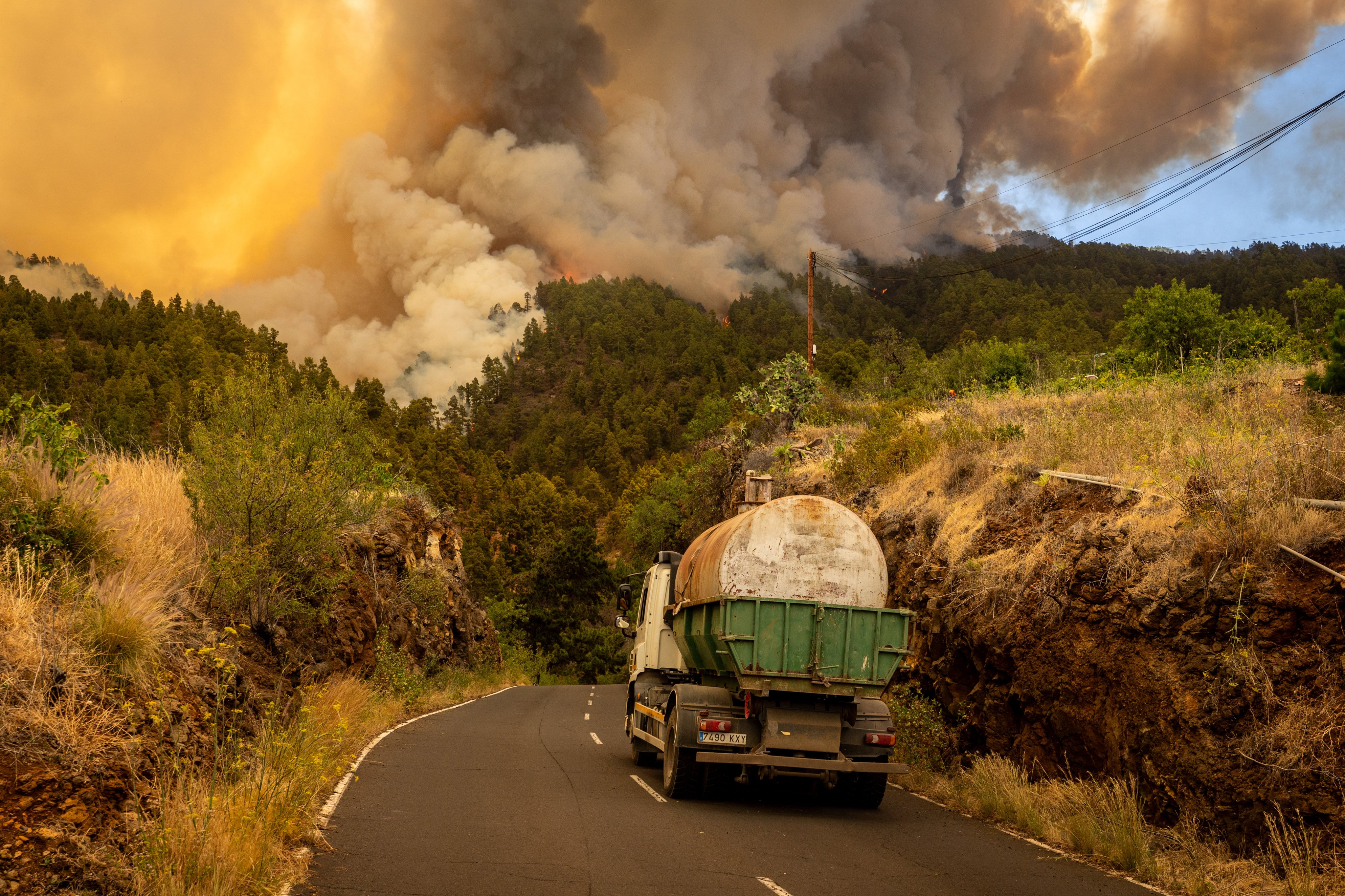 A tanker truck waits as smoke billows from a fire in La Palma, Canary Islands, Spain on Saturday. Photo: Europa Press / dpa