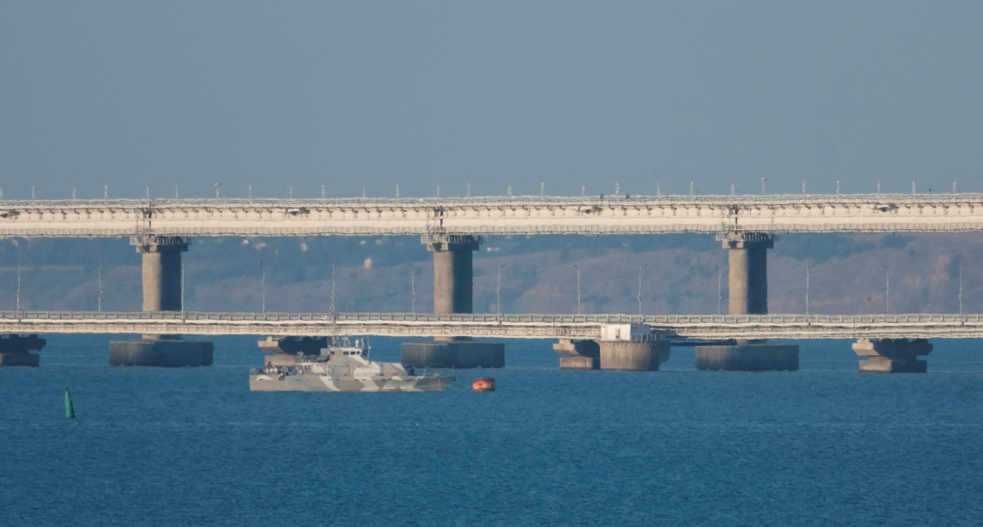An armed ship sails next to Crimean bridge connecting the Russian mainland with the peninsula across the Kerch Strait, Crimea. Photo: Reuters