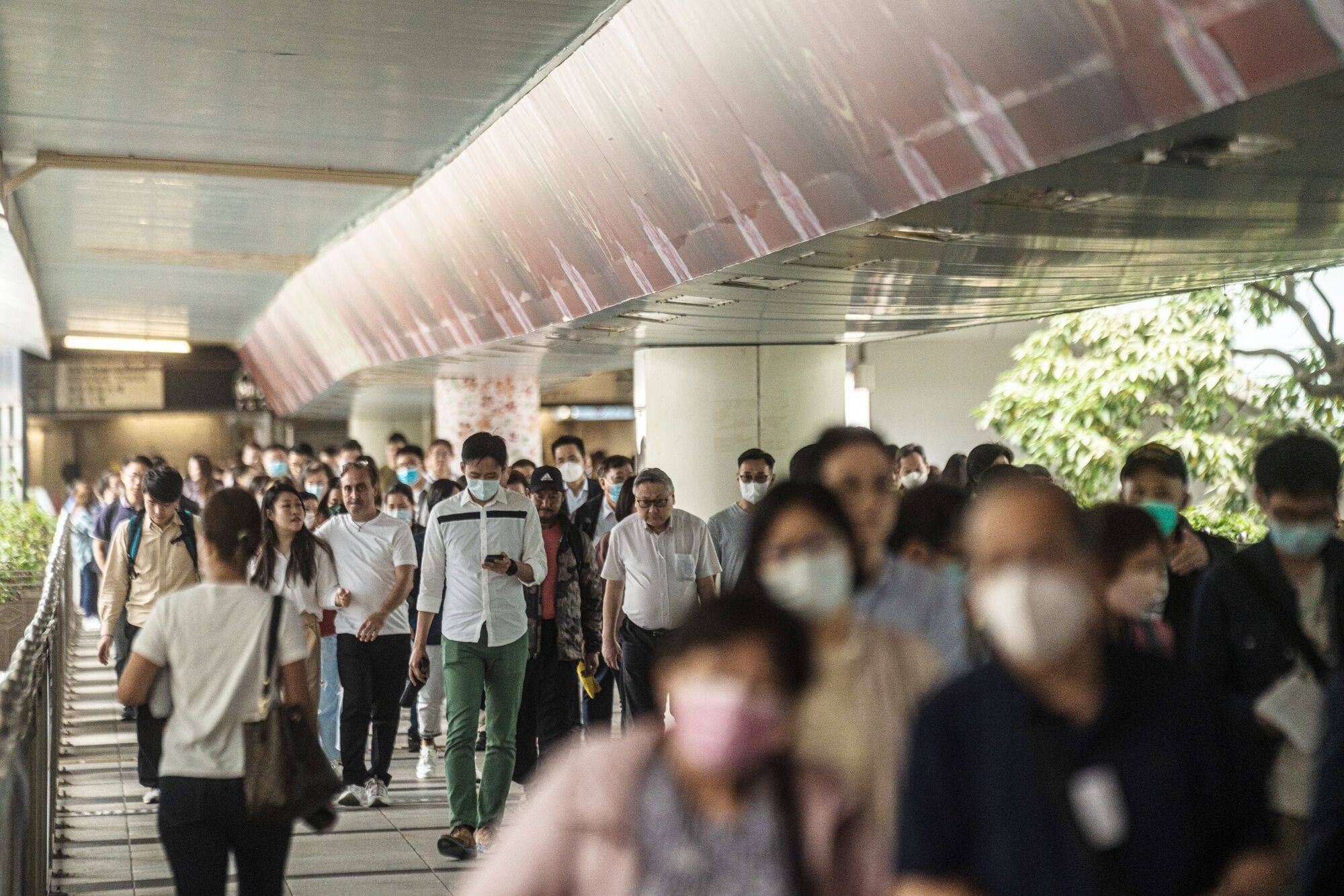 Pedestrians on a footbridge in Hong Kong. In a survey of workplace well-being conducted in February and March 2022, with respondents from 18 Asian and Western economies, Hong Kong was ranked among the bottom four. Photo: Bloomberg 