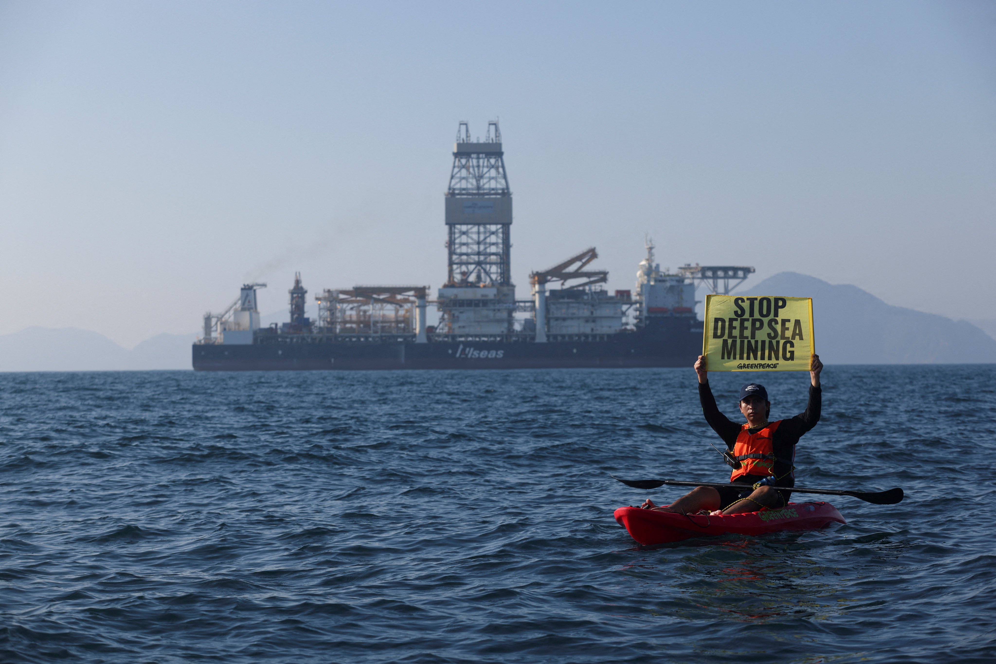 A Greenpeace activist confronts the deep sea mining vessel Hidden Gem, commissioned by Canadian miner The Metals Company, off the coast of Manzanillo, Mexico, in November 2022, as it returned to port from test mining in the Clarion-Clipperton Zone between Mexico and Hawaii. The Metals Company is among those poised to benefit from deep-sea mining projects enabled by delayed high-level negotiations. Photo: Reuters