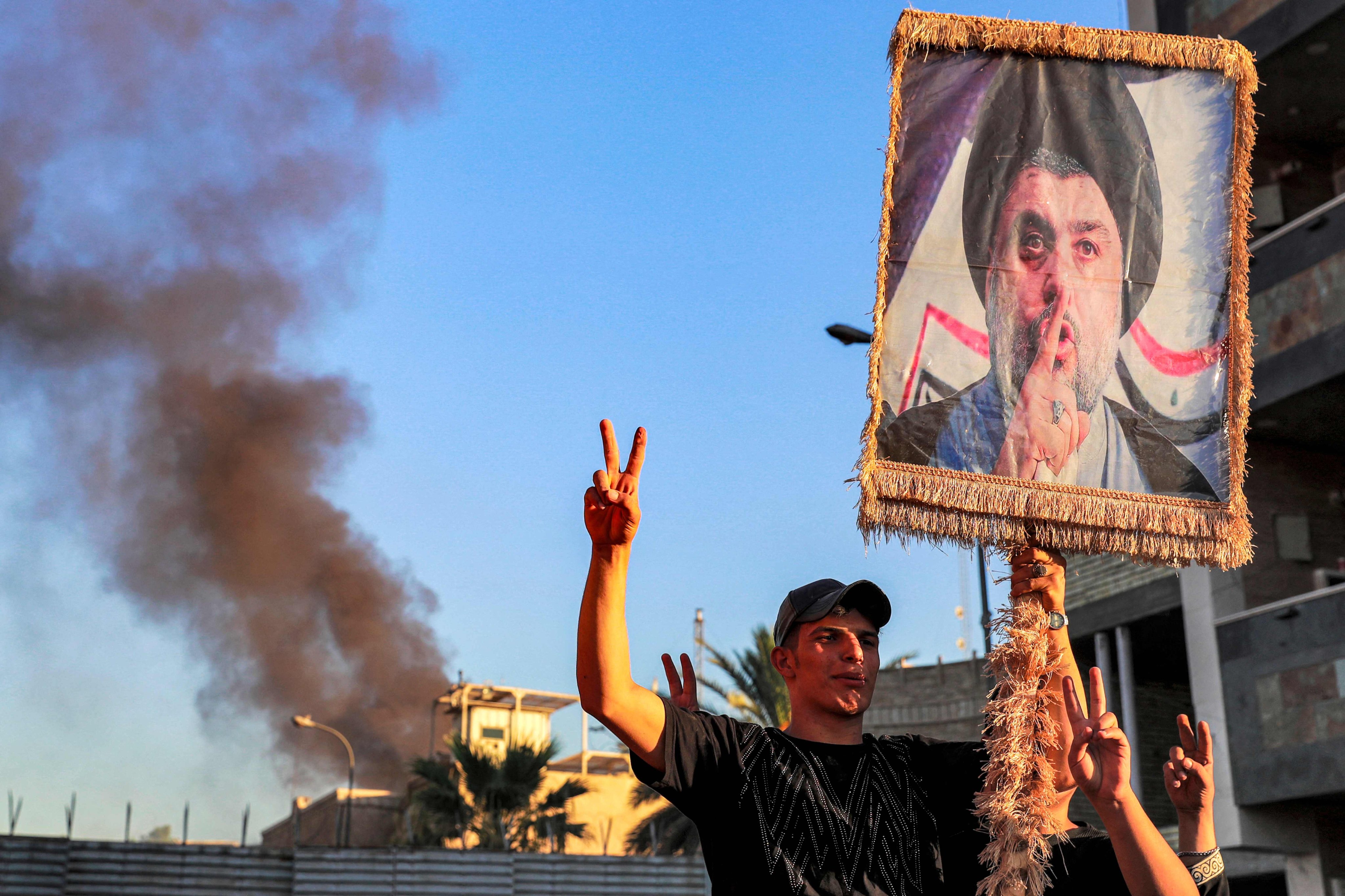 Demonstrators outside the Swedish embassy in Baghdad, which they set on fire, hold a banner with an image ofIraqi Shiite cleric Moqtada al-Sadr. Photo: AFP